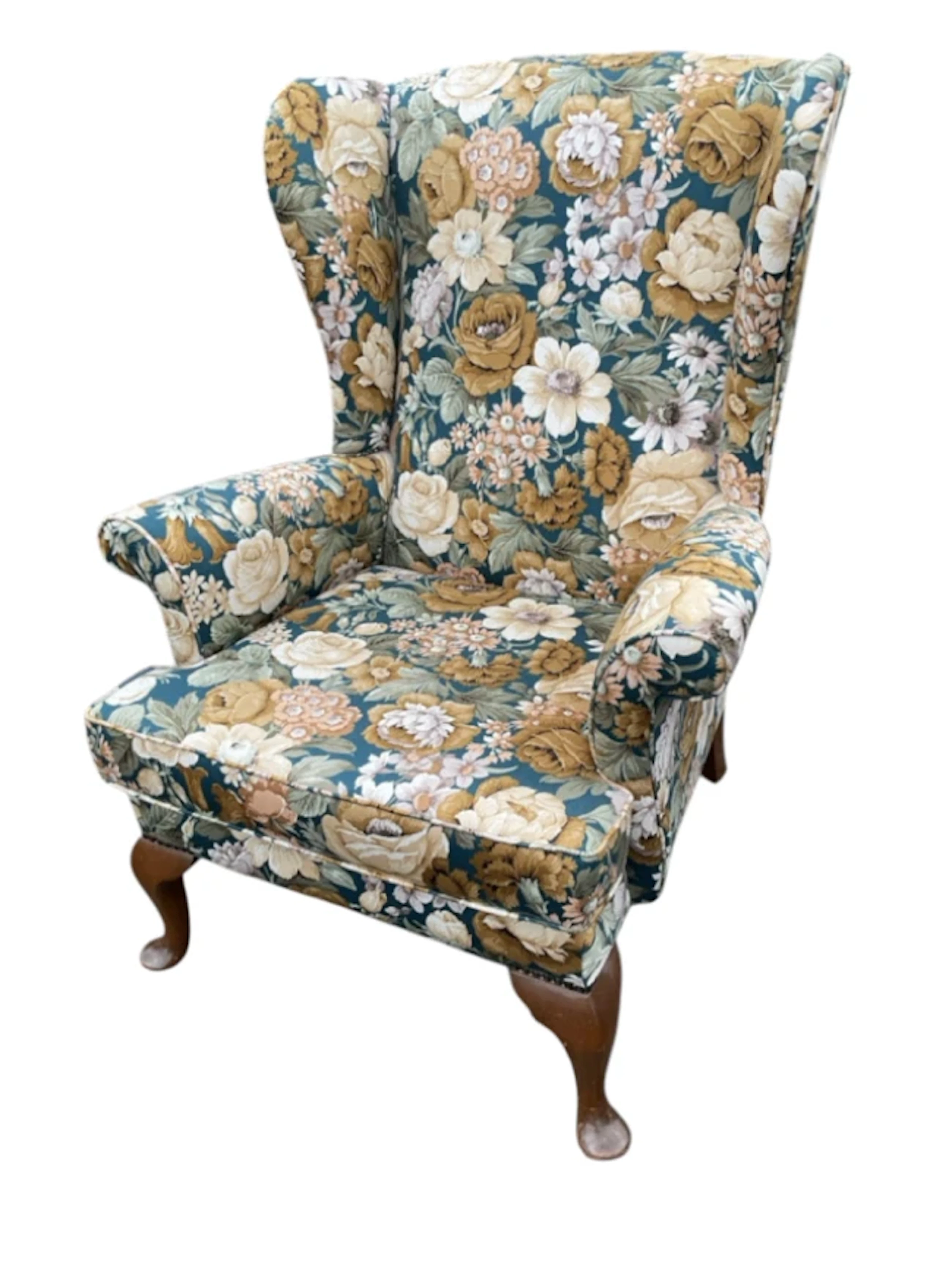 A Parker-knoll wing armchair with floral upholstery and loose cushion