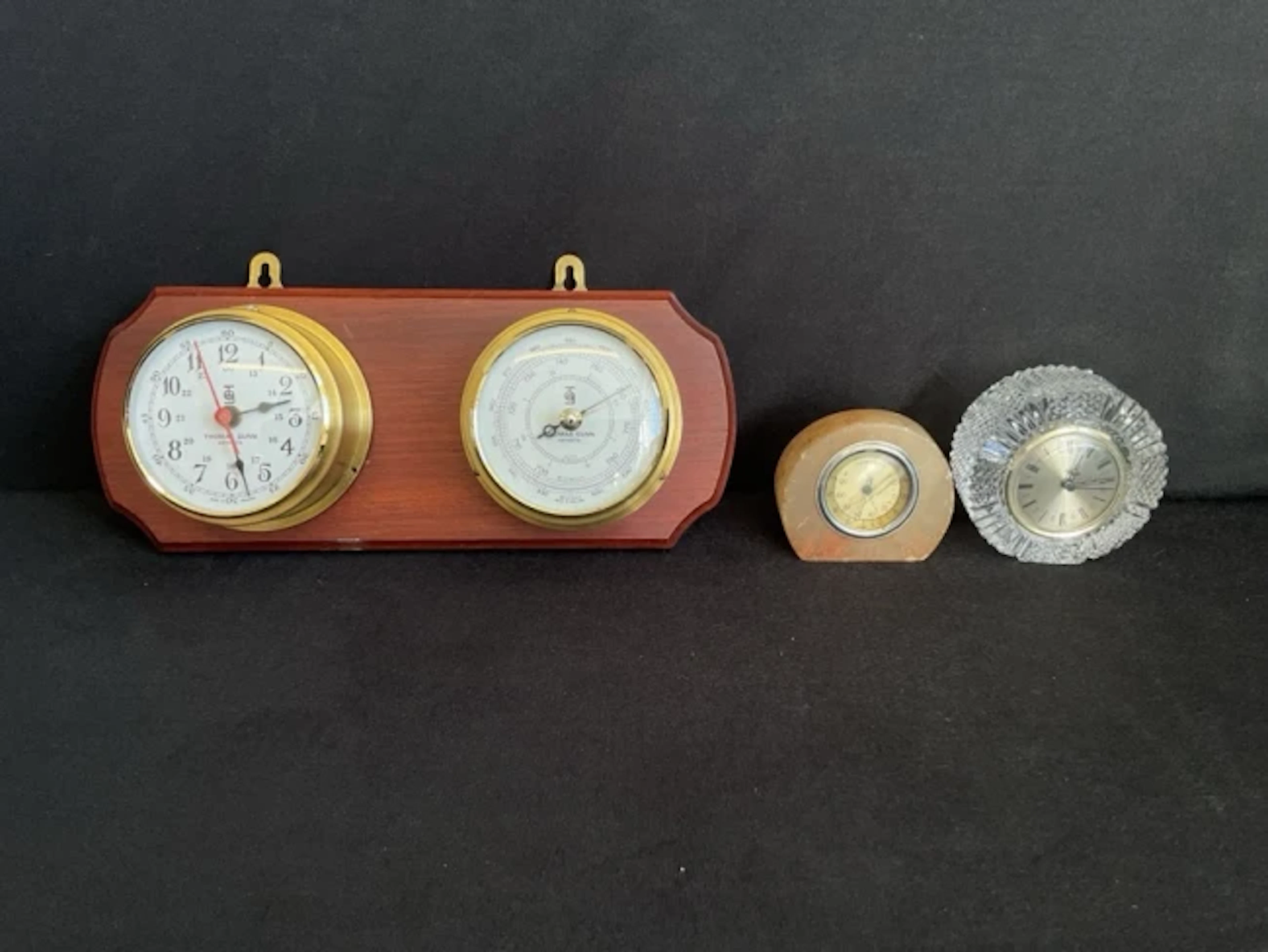 A brass ships bulkhead style cylindrical clock and barometer on a