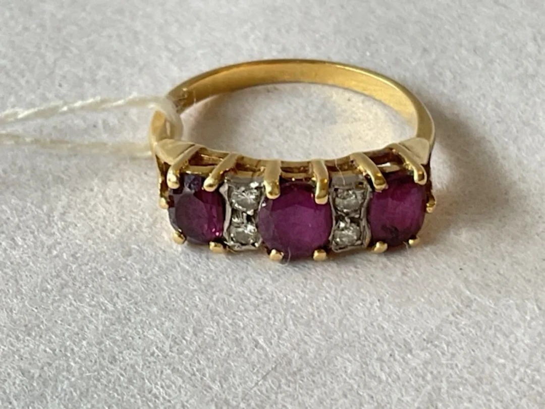 An 18ct gold ruby trilogy ring, the three oval cut stones separated
