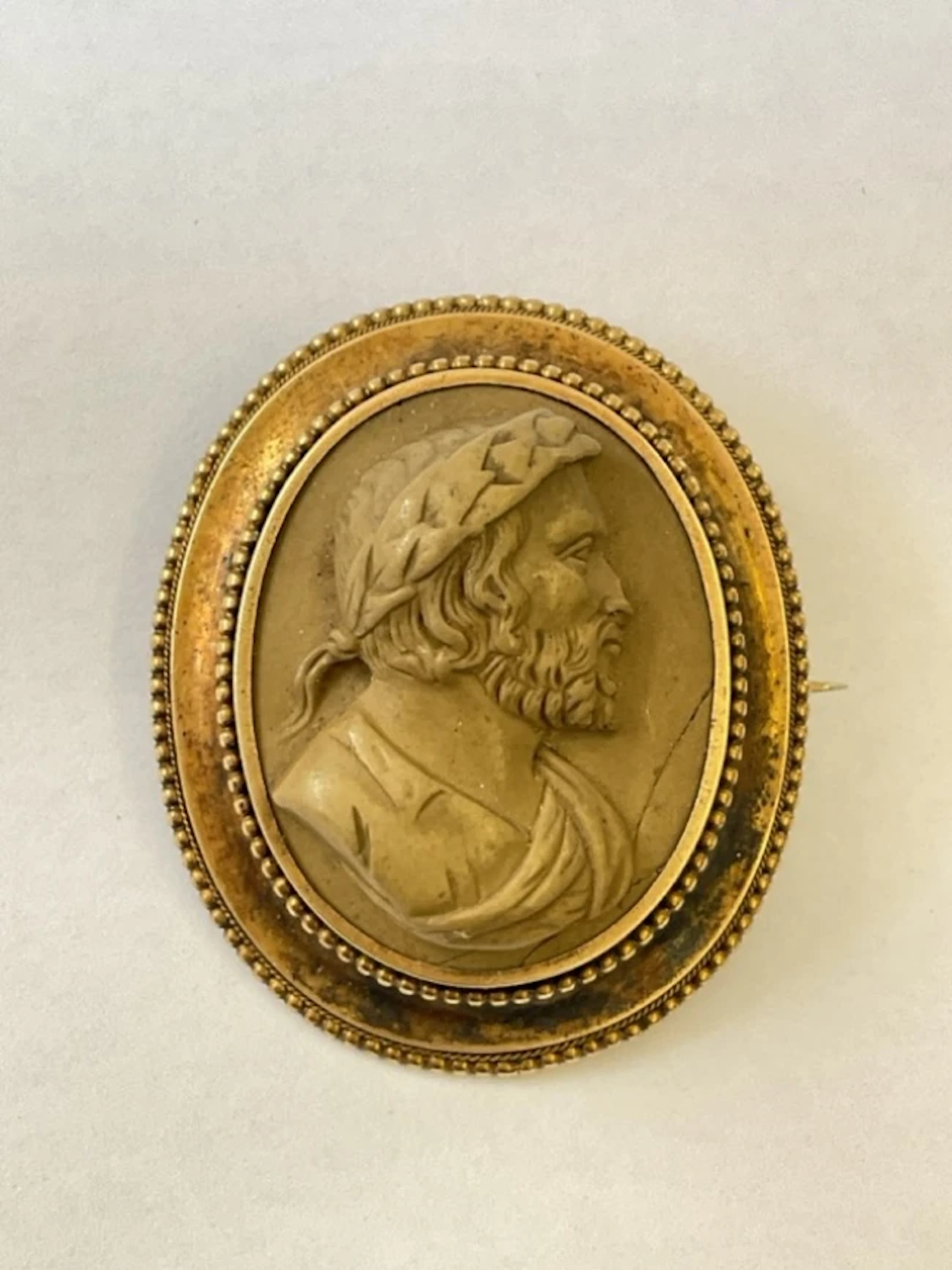 An oval Victorian lava cameo with man wearing laurel wreath, set in