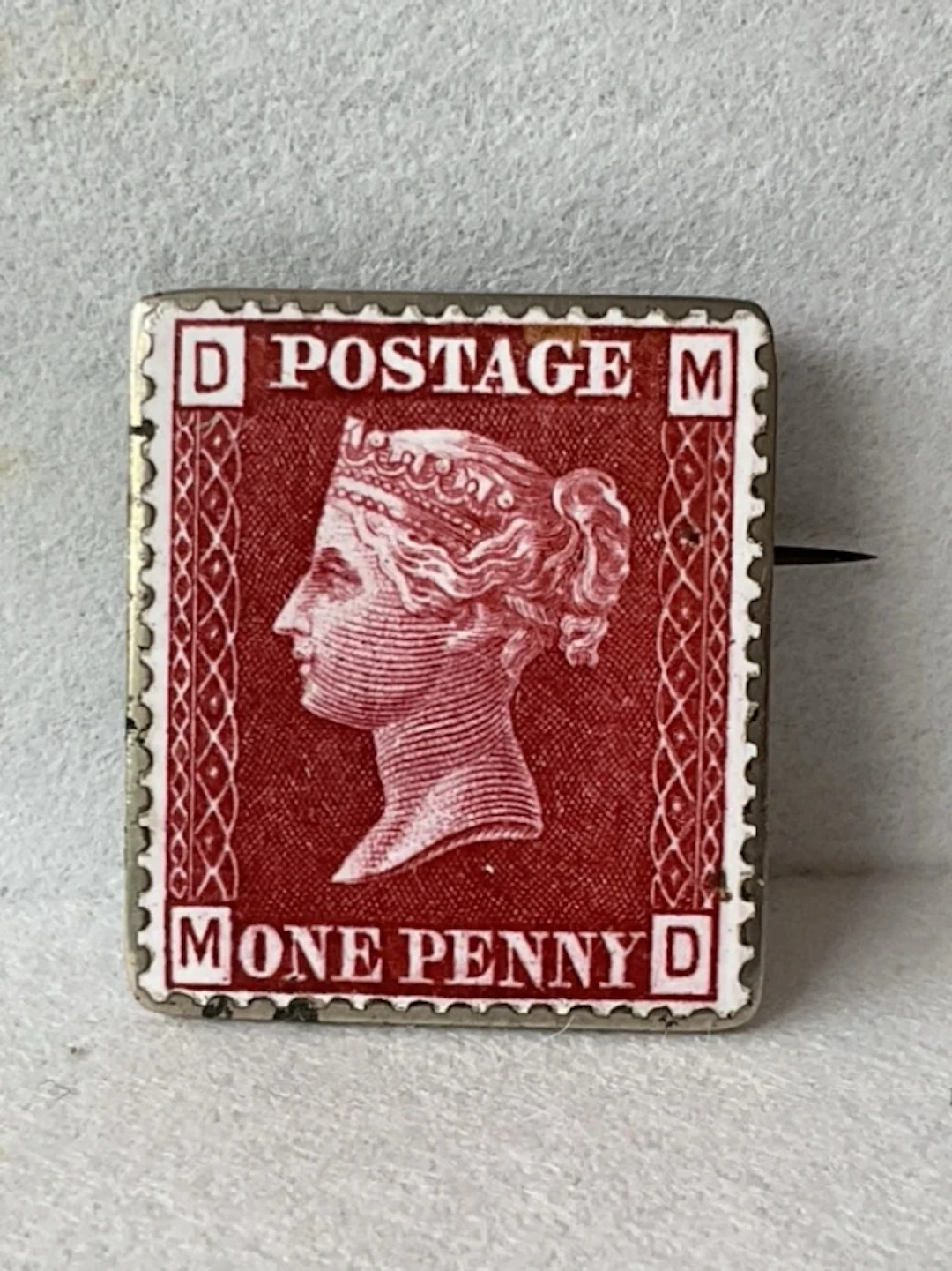 An antique enamelled silver Penny Red stamp brooch. (1in)