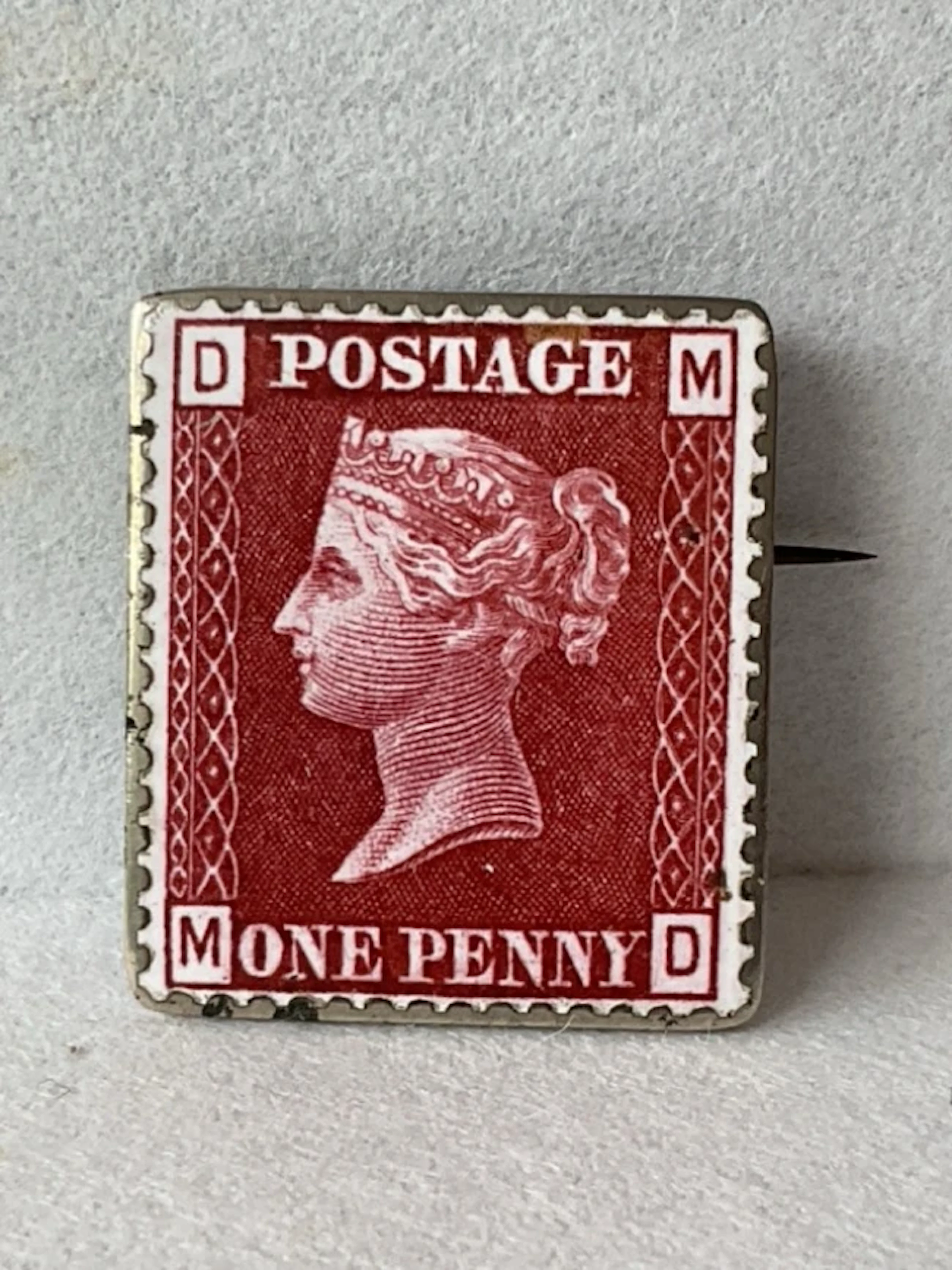 An antique enamelled silver Penny Red stamp brooch. (1in)