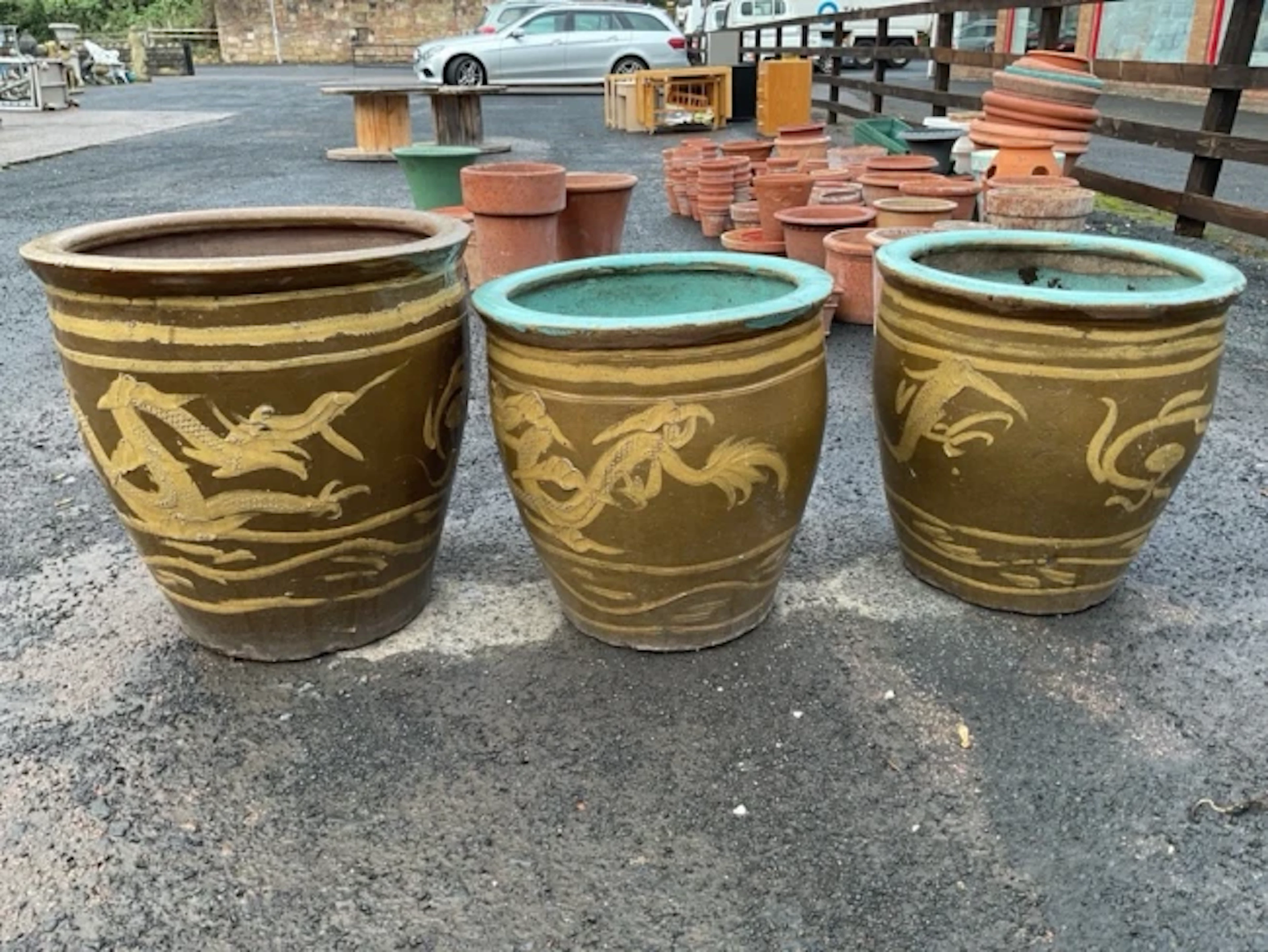 A pair of large stoneware garden urns with salt glazed dragon decoration