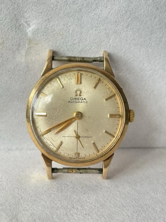 A gents 9ct gold Omega Automatic wristwatch, the champagne dial having