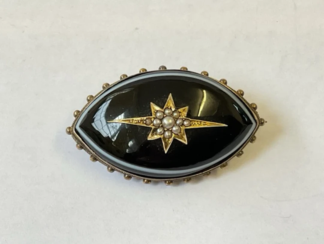 An antique banded agate memorial brooch in unmarked 15ct gold, set