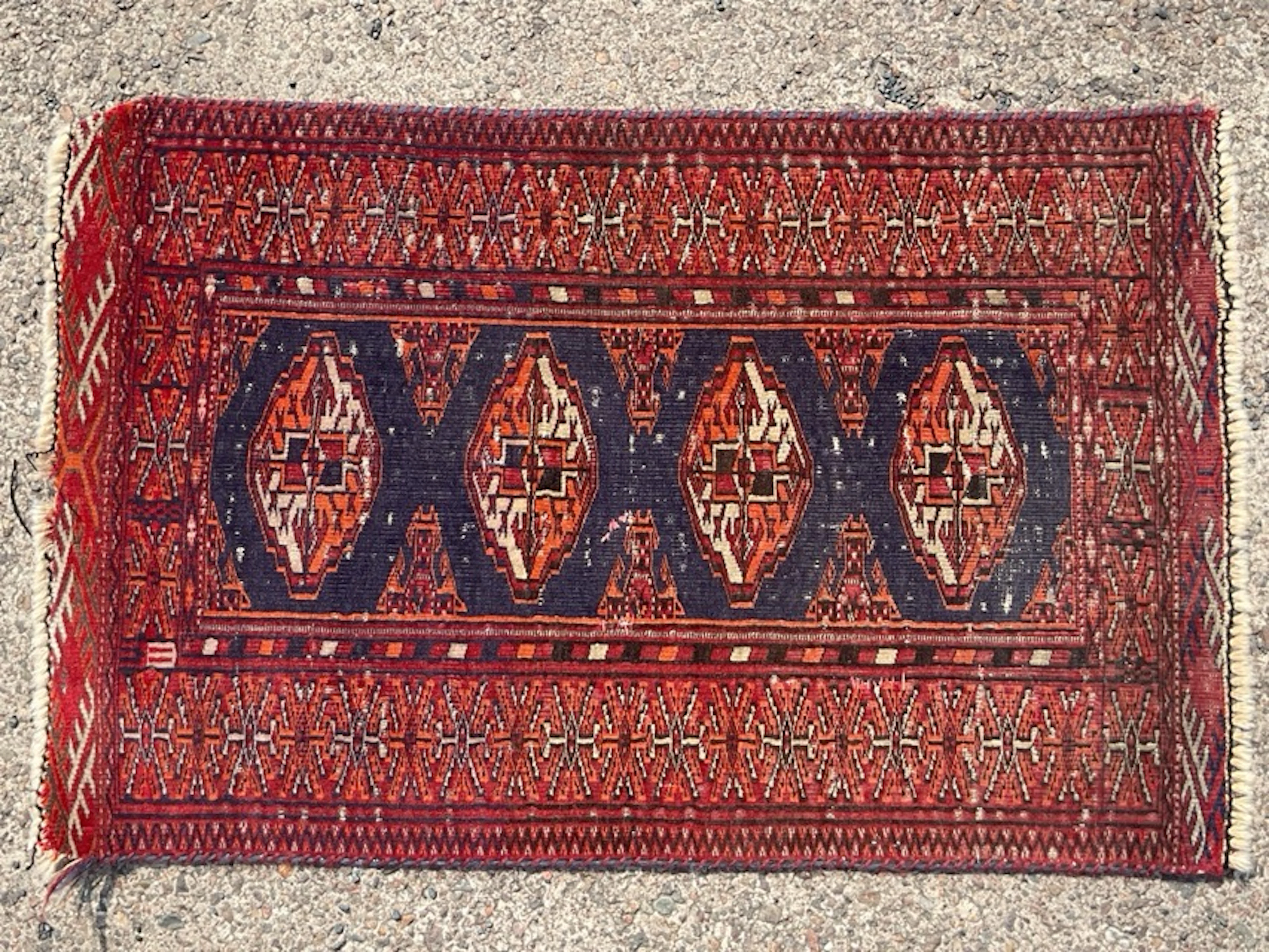 A Turkmen wool rug woven with four panels gul medallions...