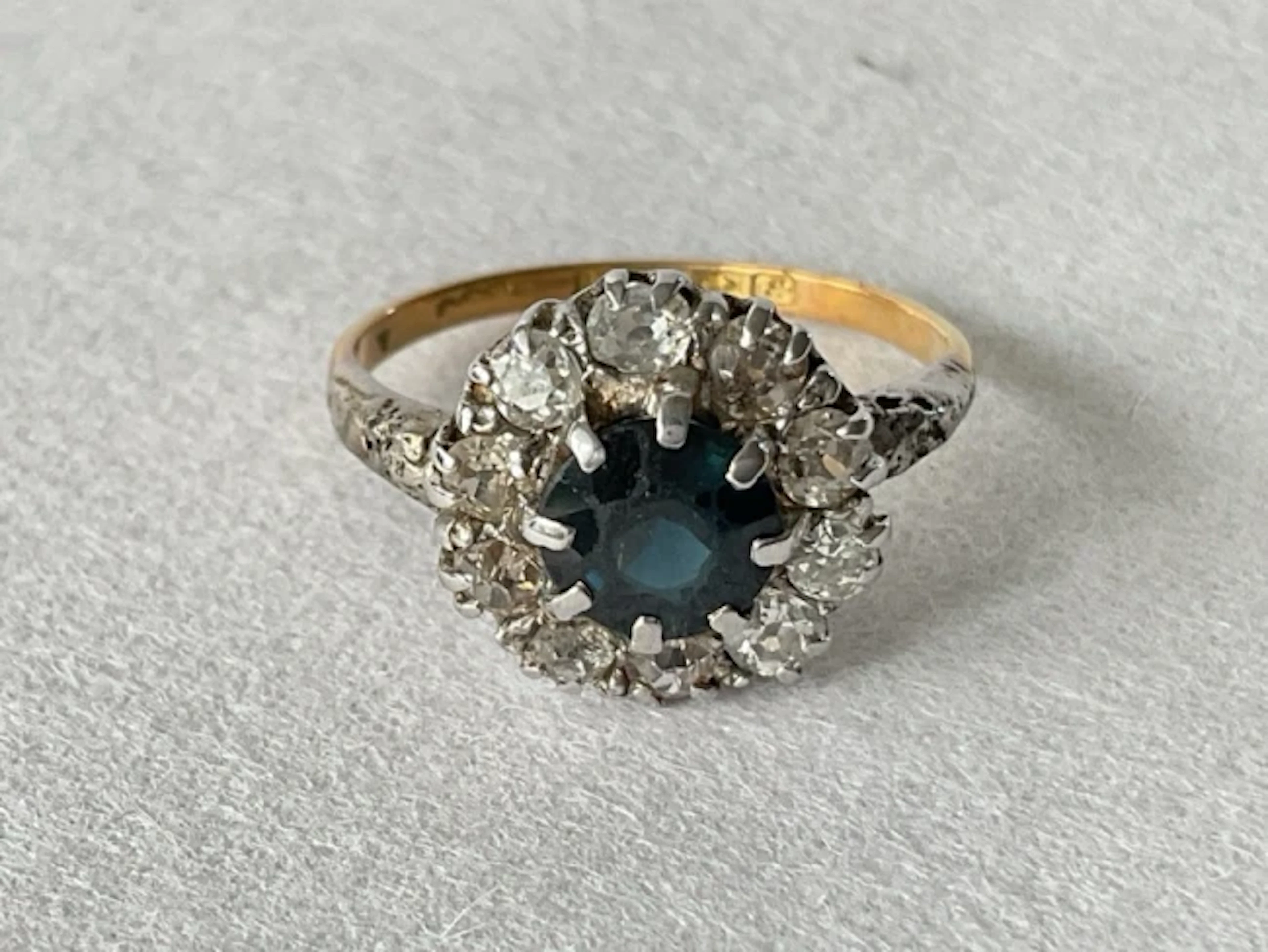 An 18ct gold sapphire cluster ring, the central circular claw set