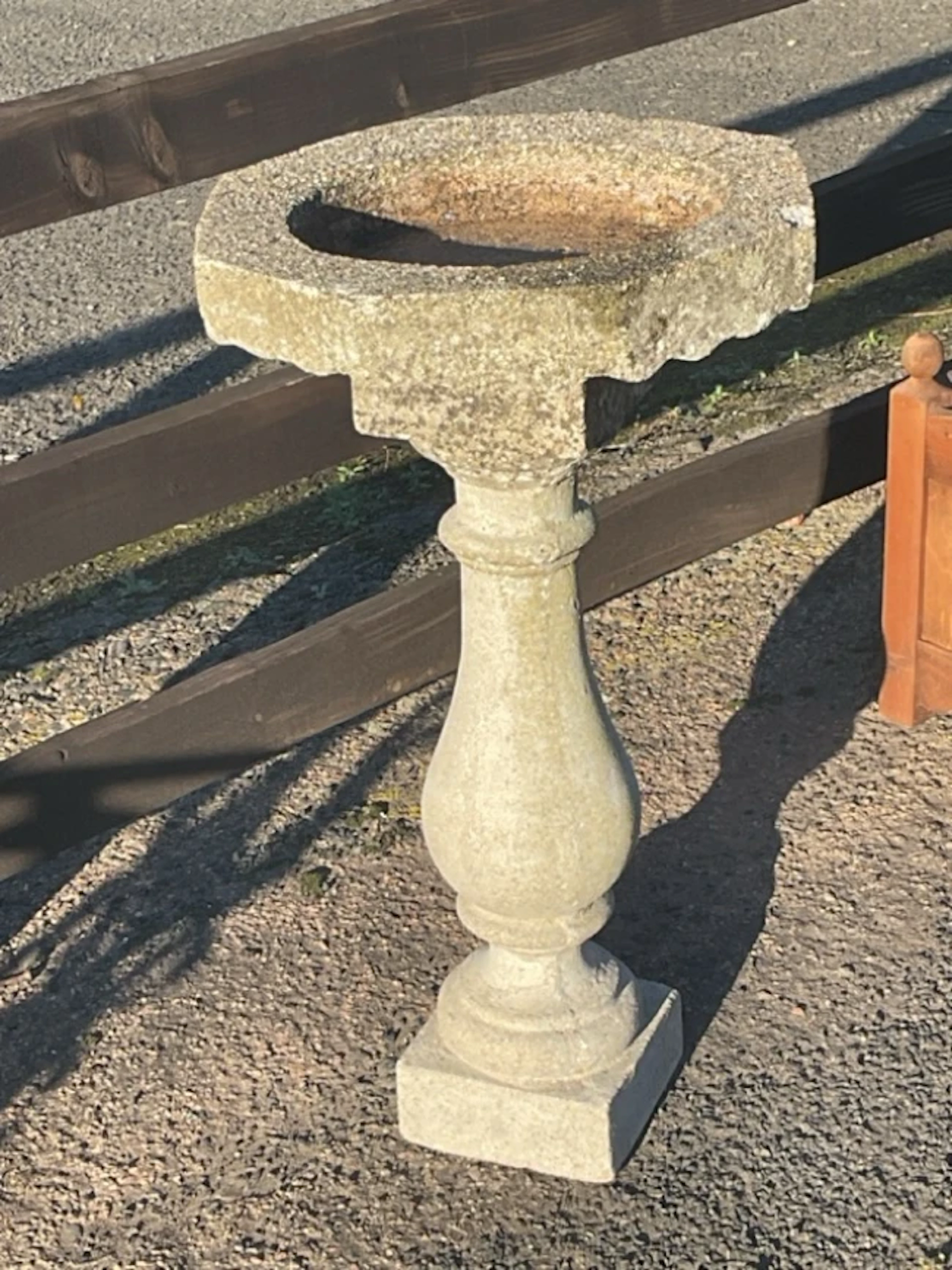 A composition stone birdbath with octagonal bowl on baluster shaped