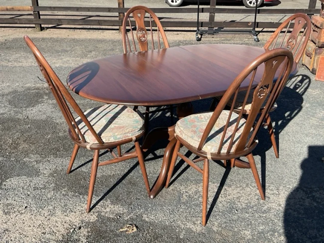 An Ercol elm table & chair set, the four chairs with swan medallions