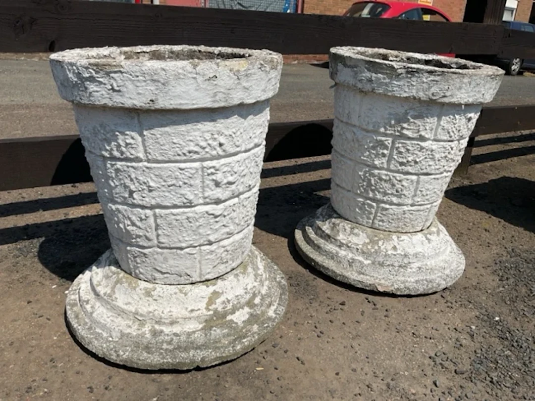 A pair of painted composition stone garden urns with tapering faux