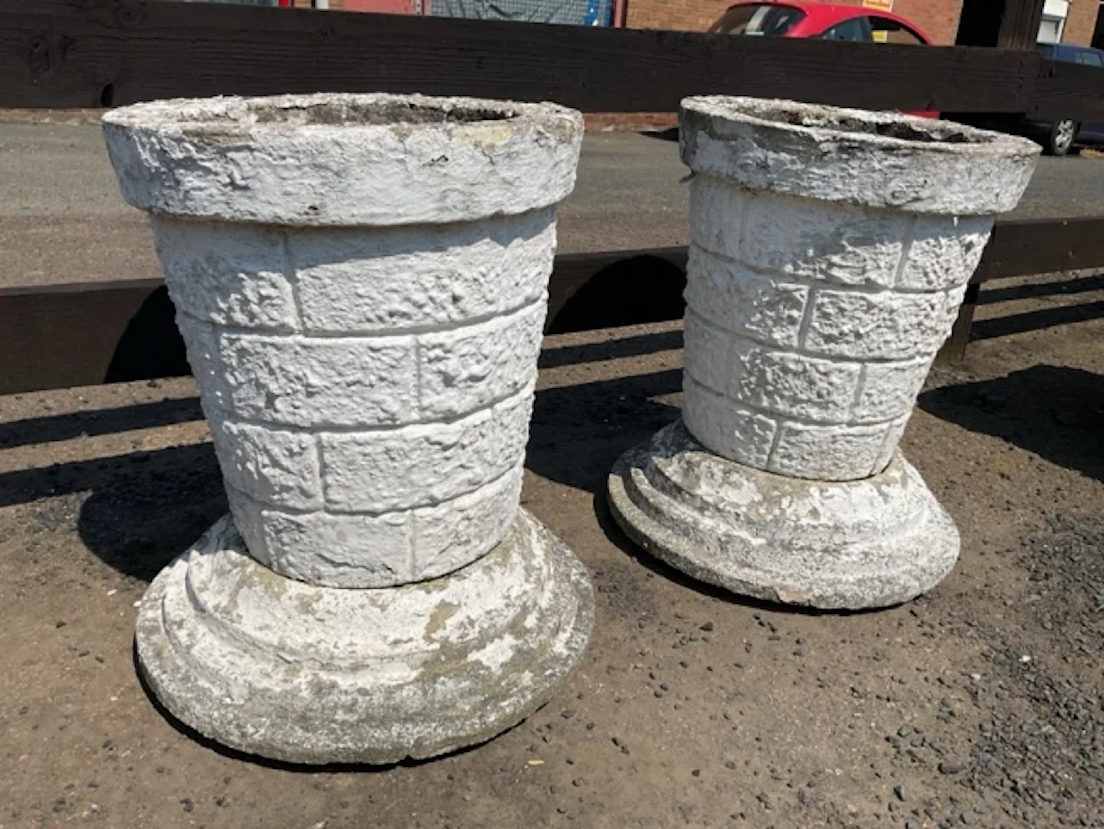 A pair of painted composition stone garden urns with tapering faux