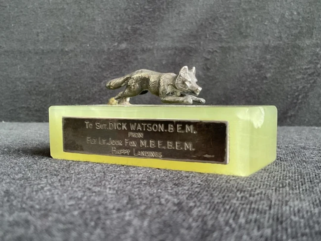 A match striker with an unmarked cast silver figure of a running fox