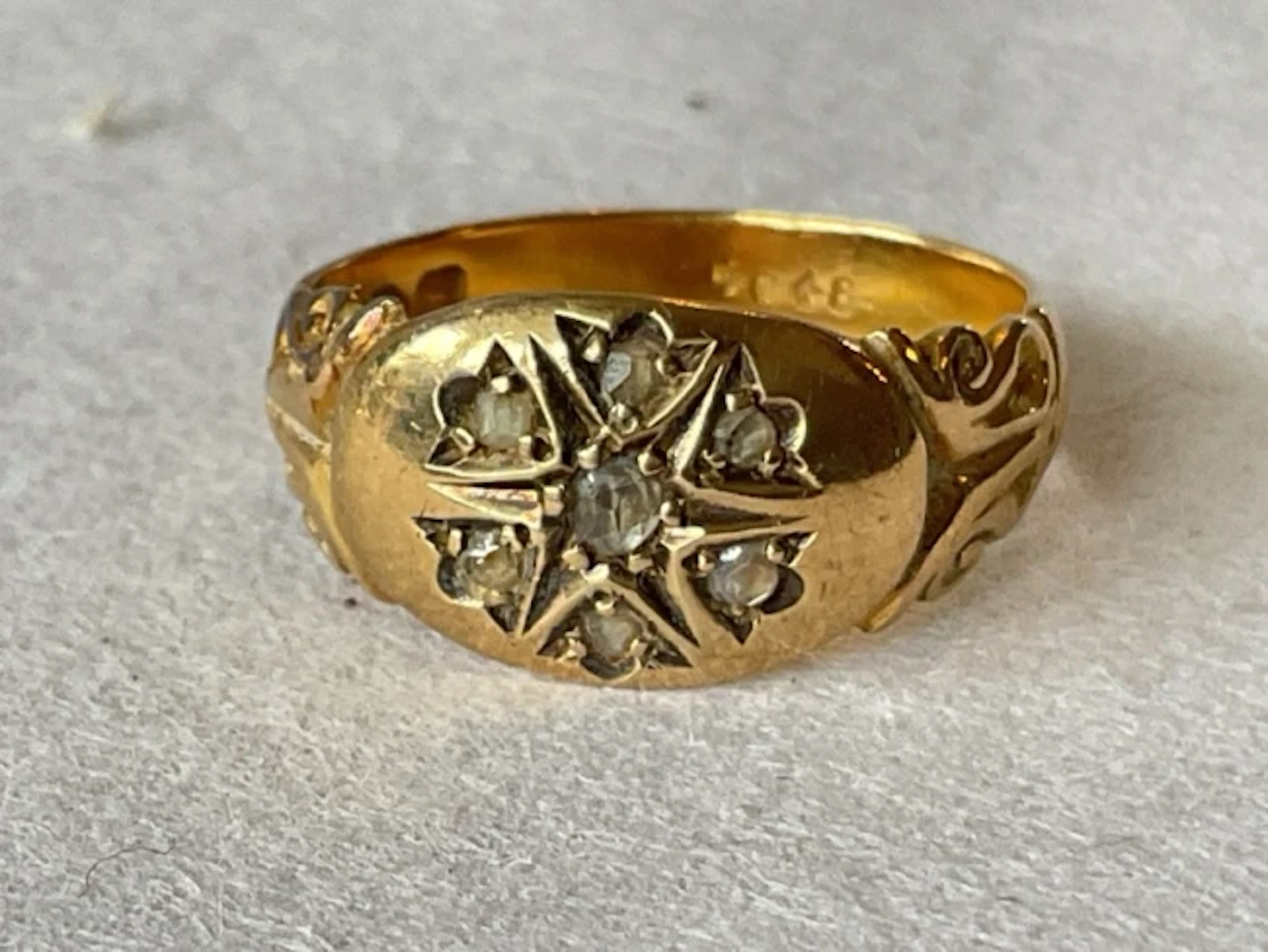 An antique 18ct gold wedding band set with seven diamonds, flanked