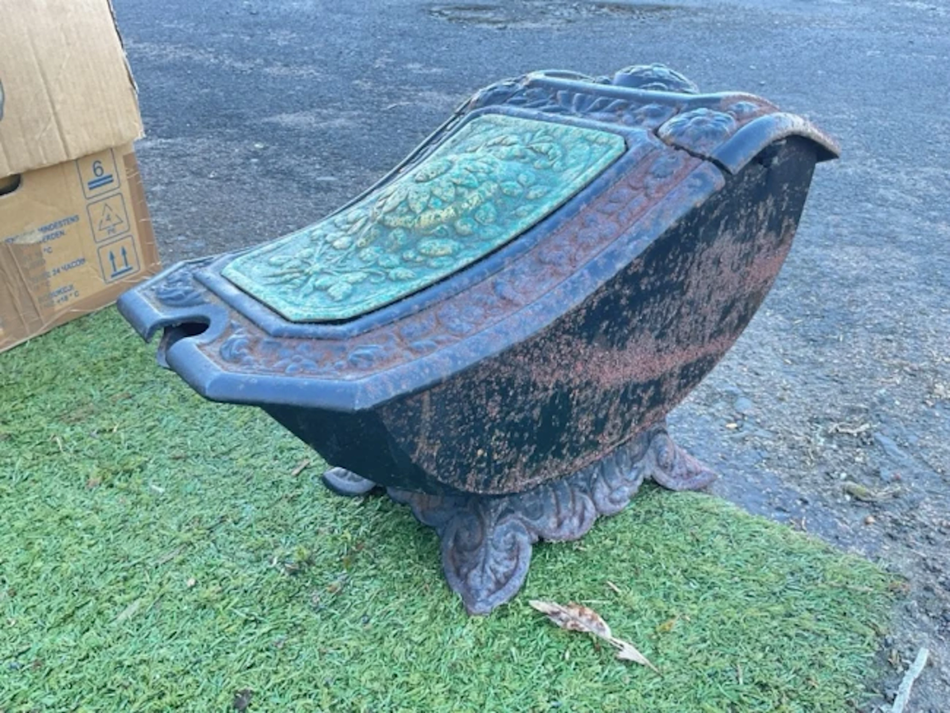 A Victorian cast iron coal scuttle having shaped hinged cover with