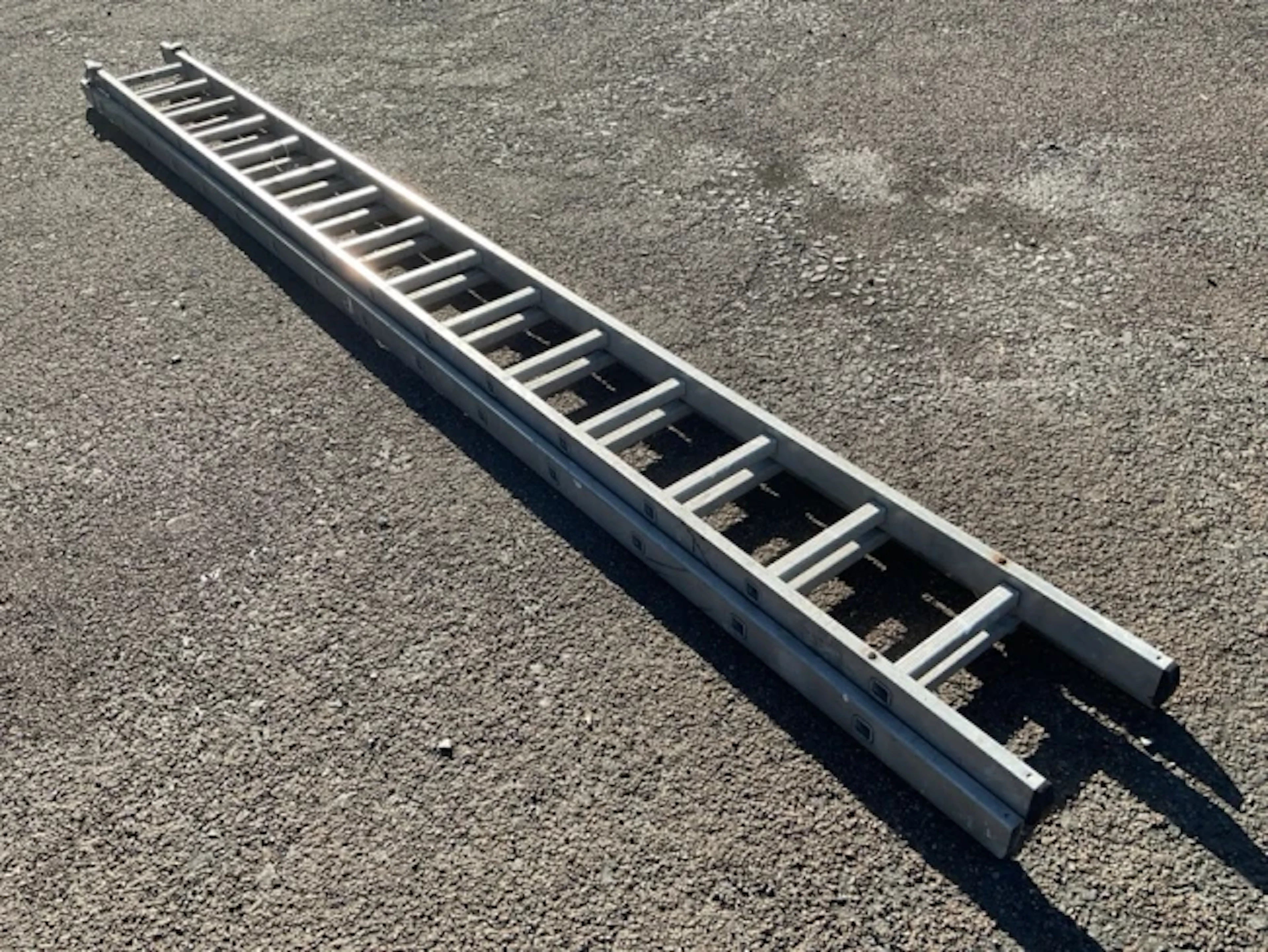 A long two-piece extension ladder, each section with fifteen square