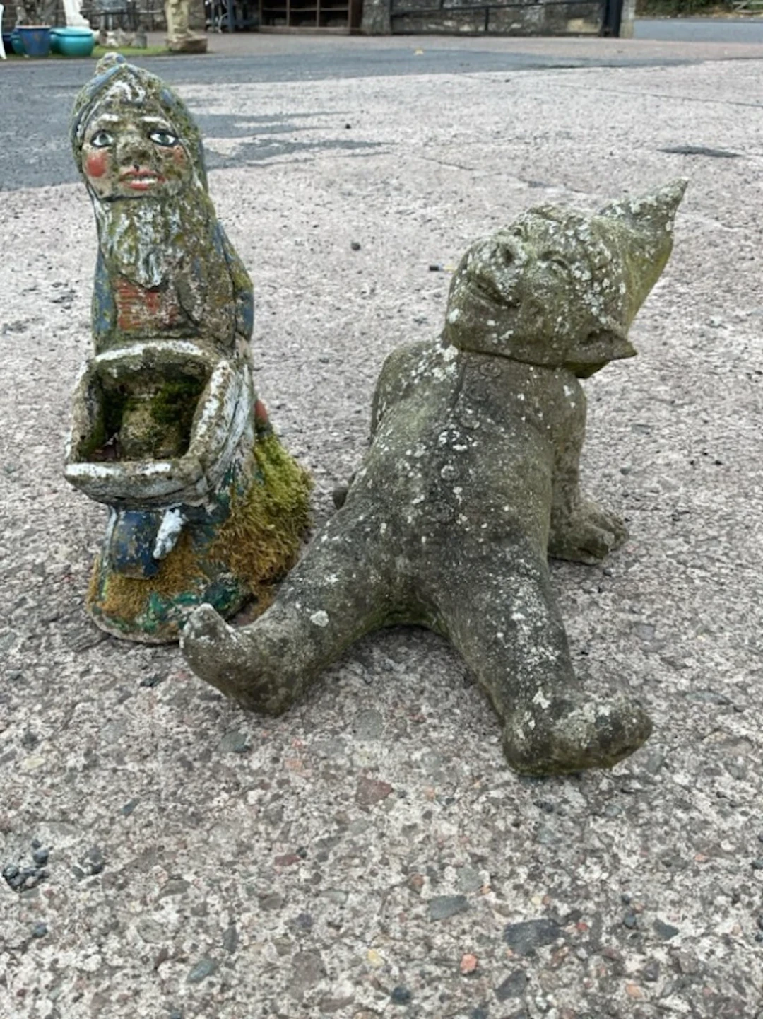 A lying laughing composition stone garden gnome; and a painted garden