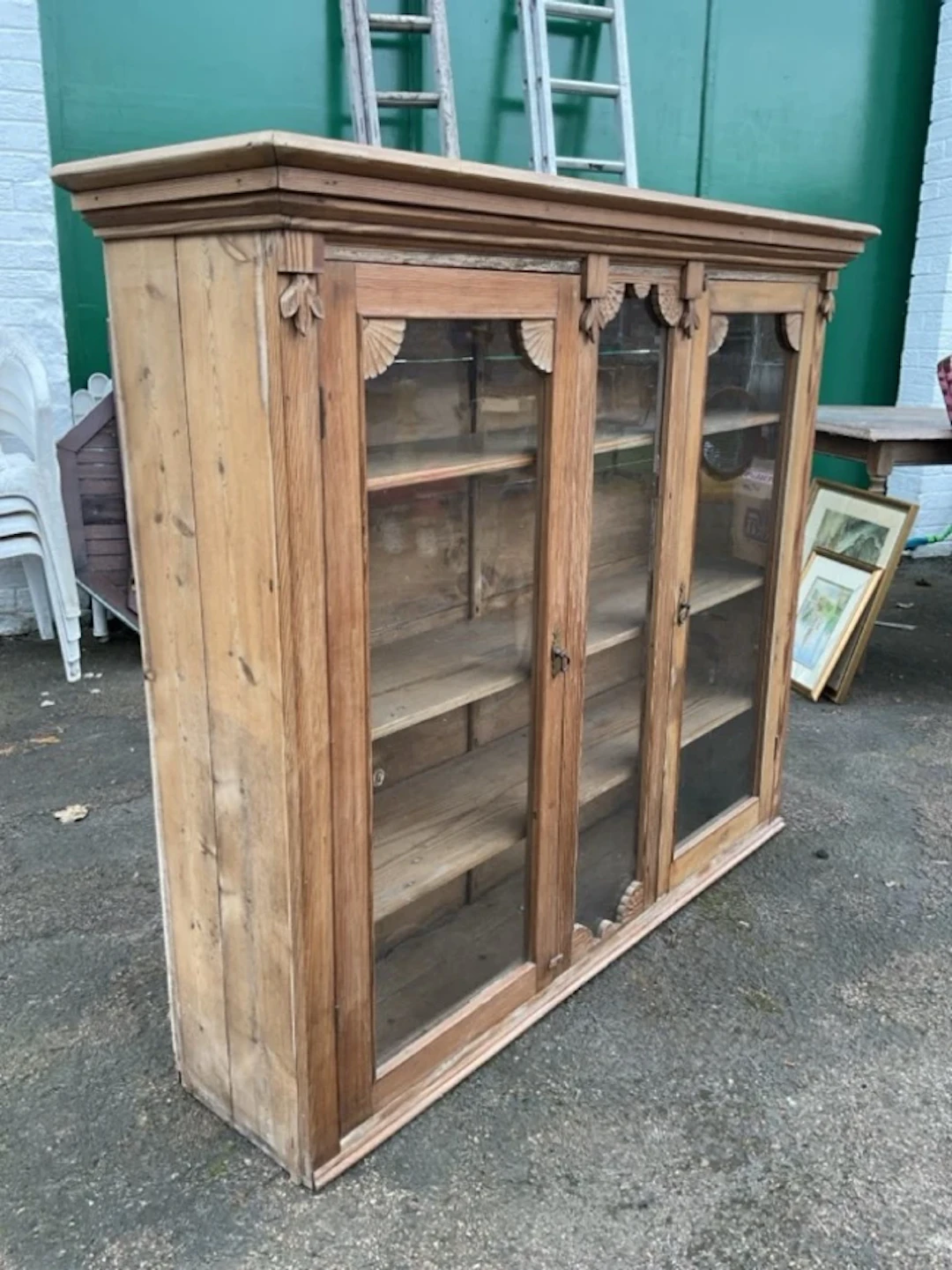 A Victorian glazed pine cabinet with moulded cornice above two glass