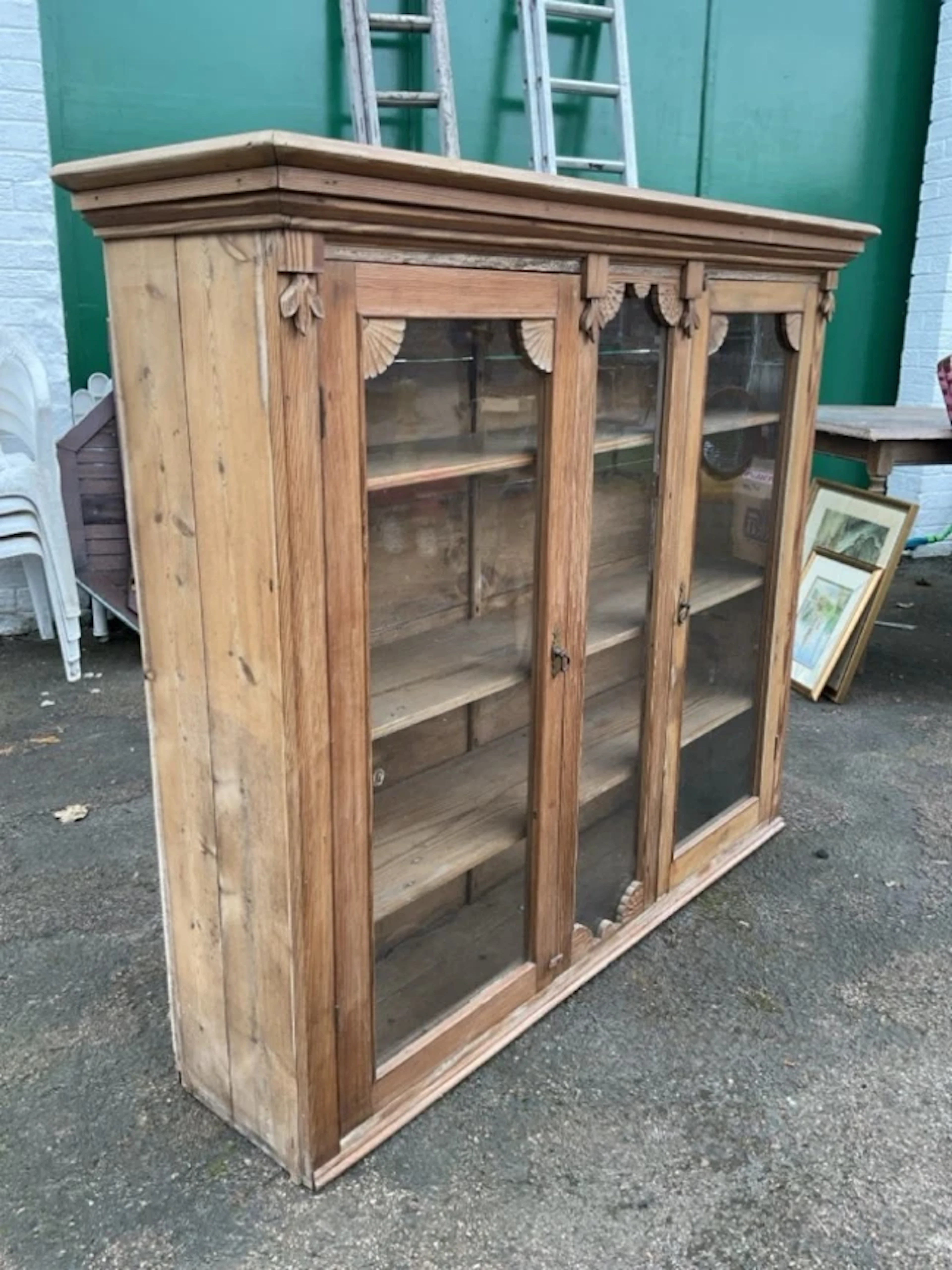 A Victorian glazed pine cabinet with moulded cornice above two glass
