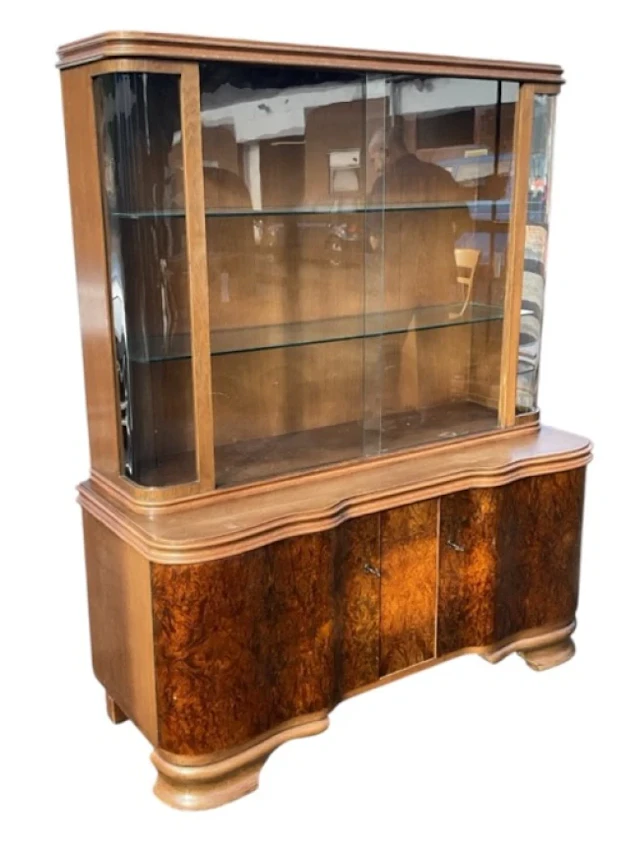 A continental walnut display cabinet with rounded glass ends and sliding