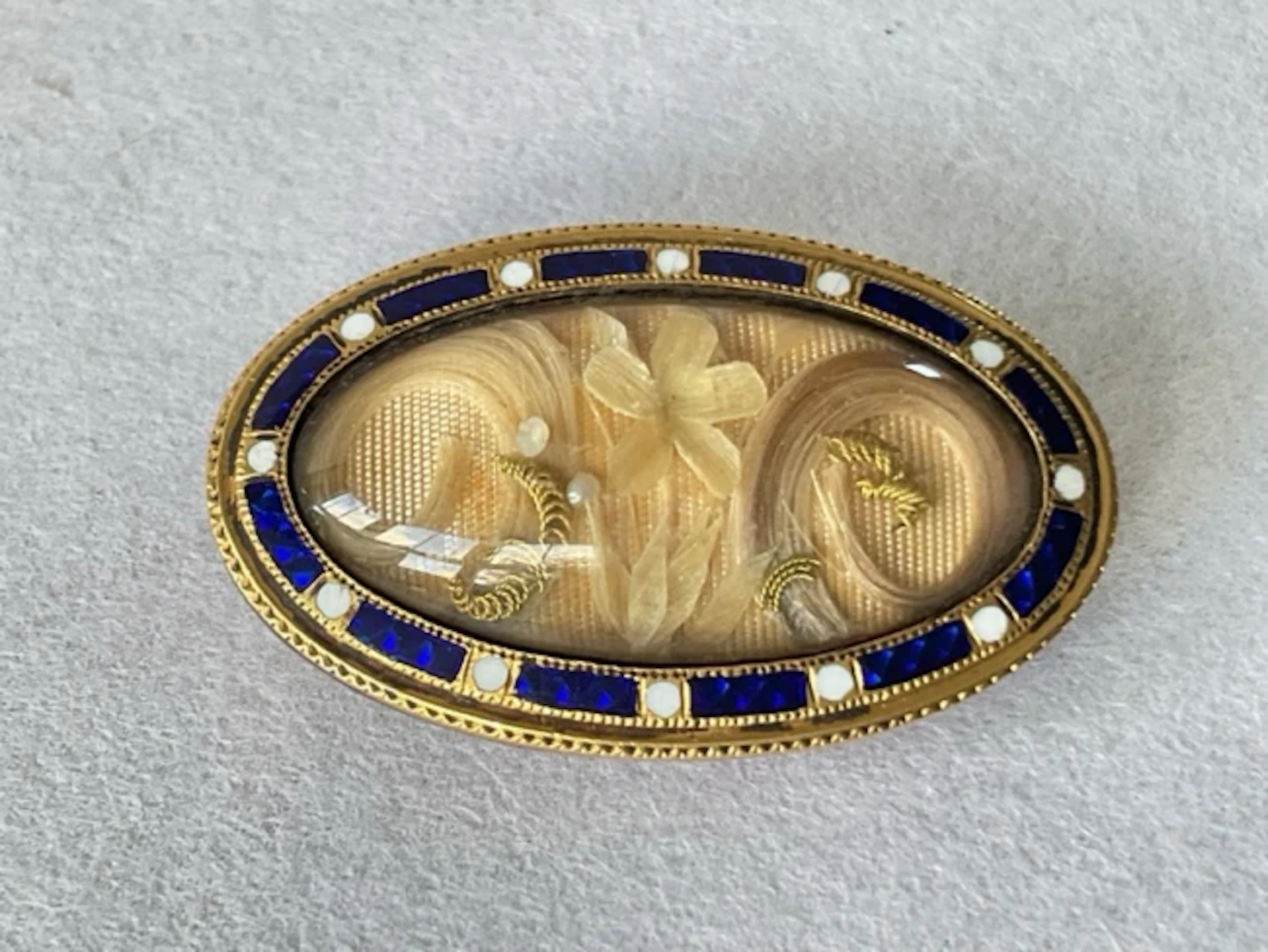 An early C19th gold memorial brooch having domed glass compartment