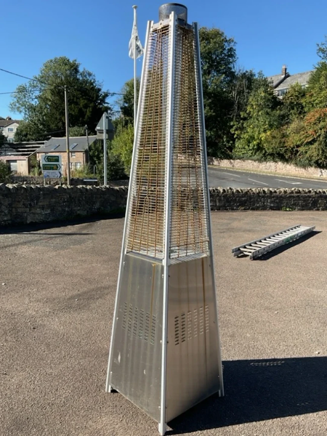 A gas powered garden patio heater with glass flu tube in square tapering
