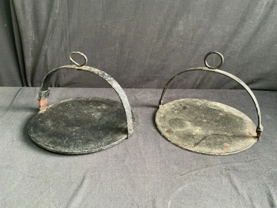 Two Victorian circular cast iron griddle plates with arched wrought