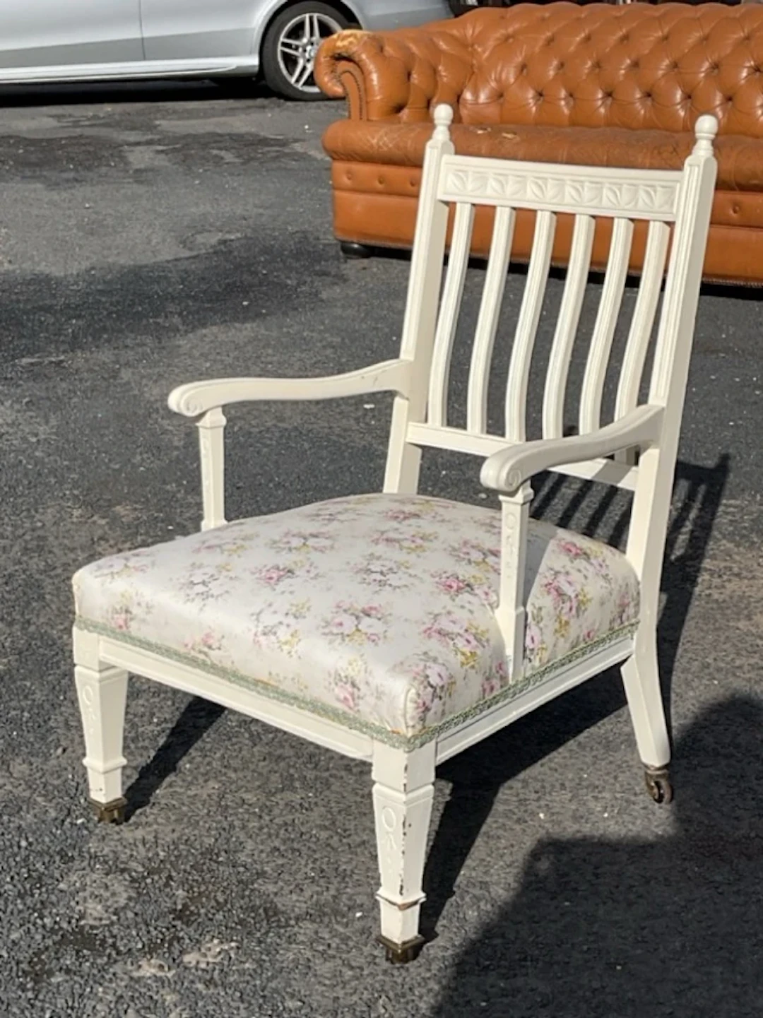 An Edwardian painted armchair with leaf carved crestrail and back