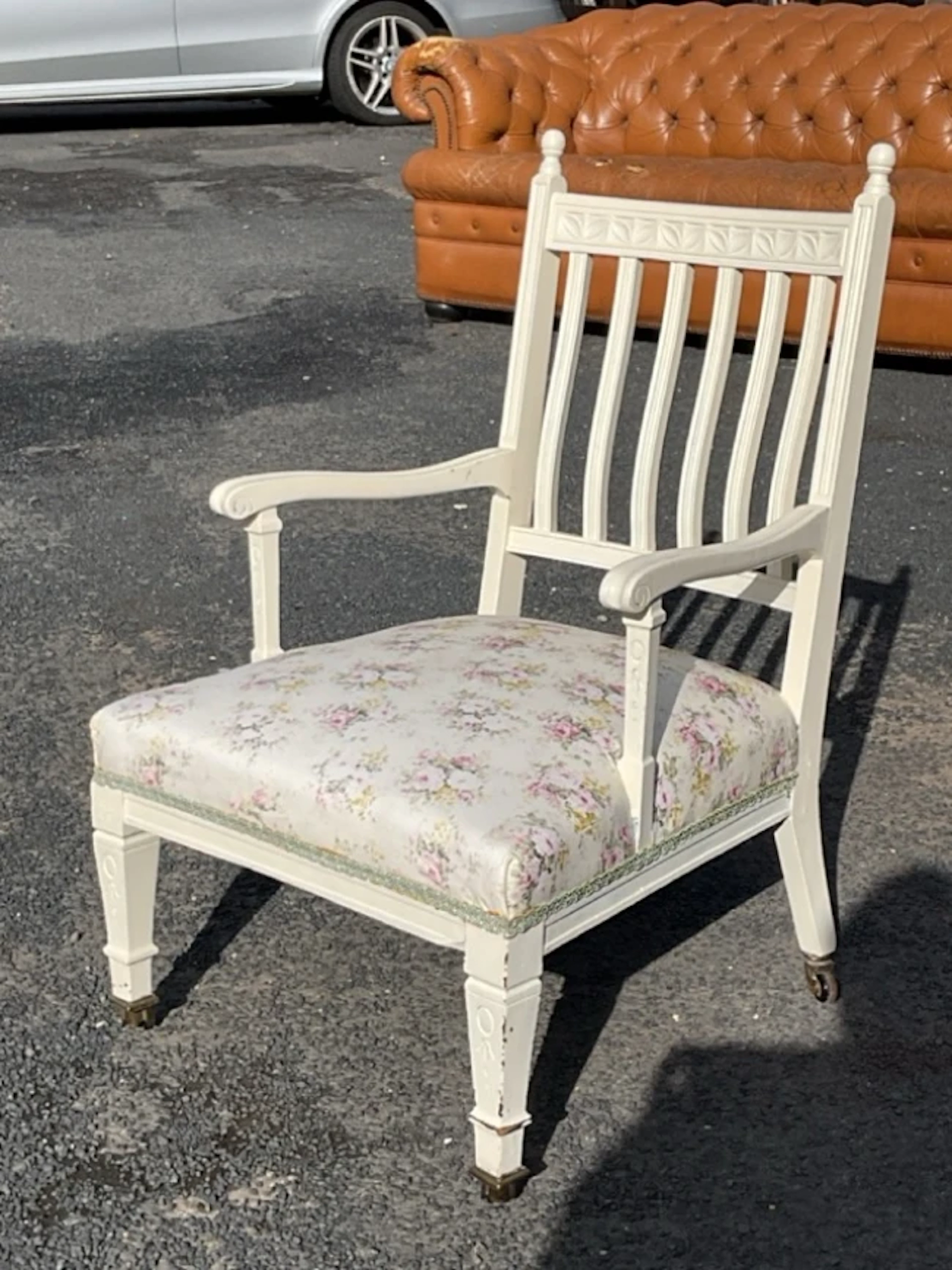 An Edwardian painted armchair with leaf carved crestrail and back