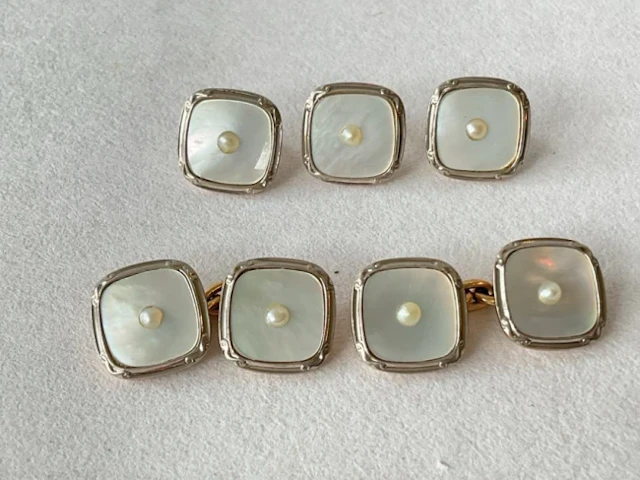 A mother-of-pearl cufflink and stud set with central seed pearls