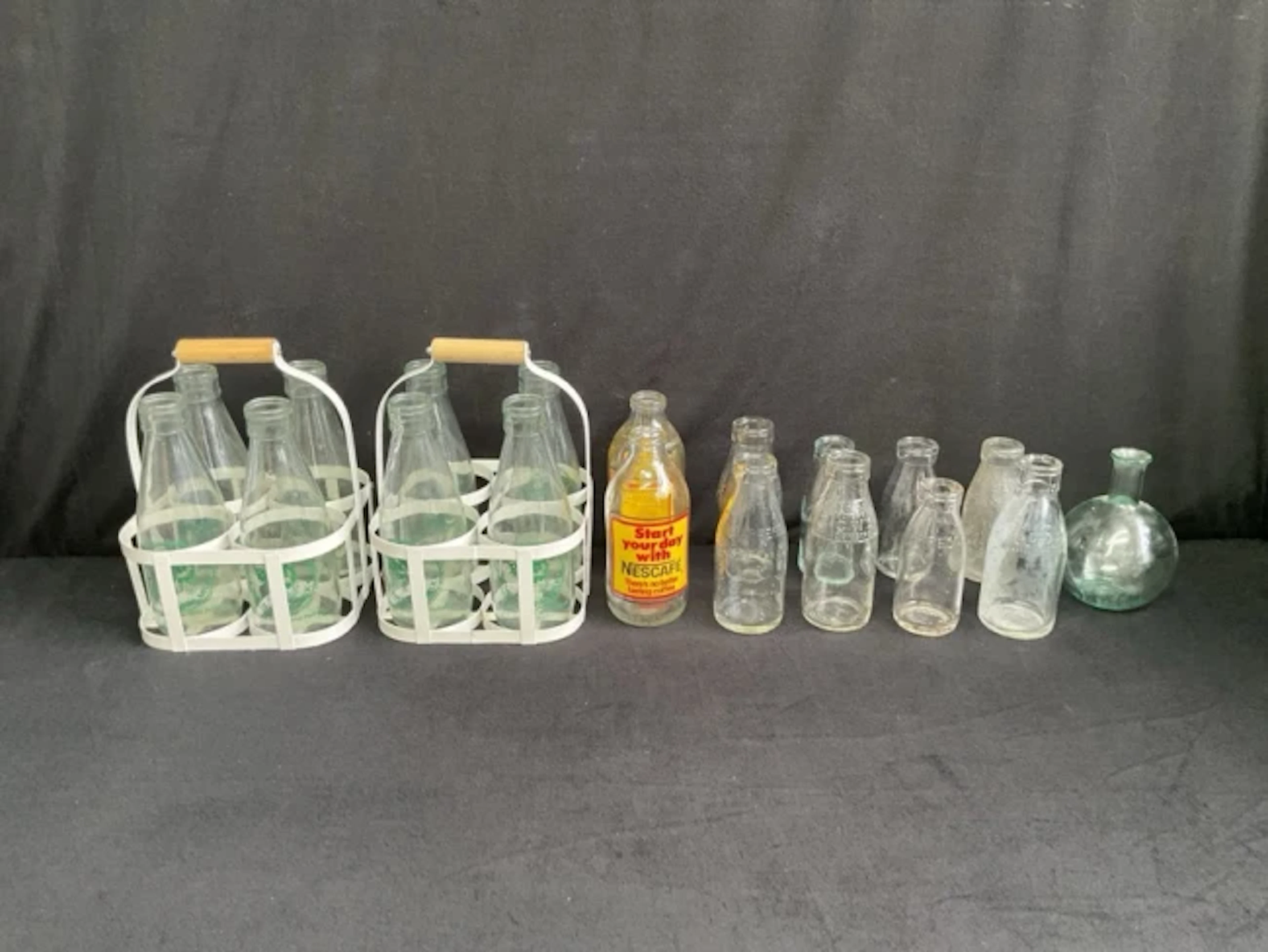 A collection of vintage pint and half-pint milk bottles with moulded