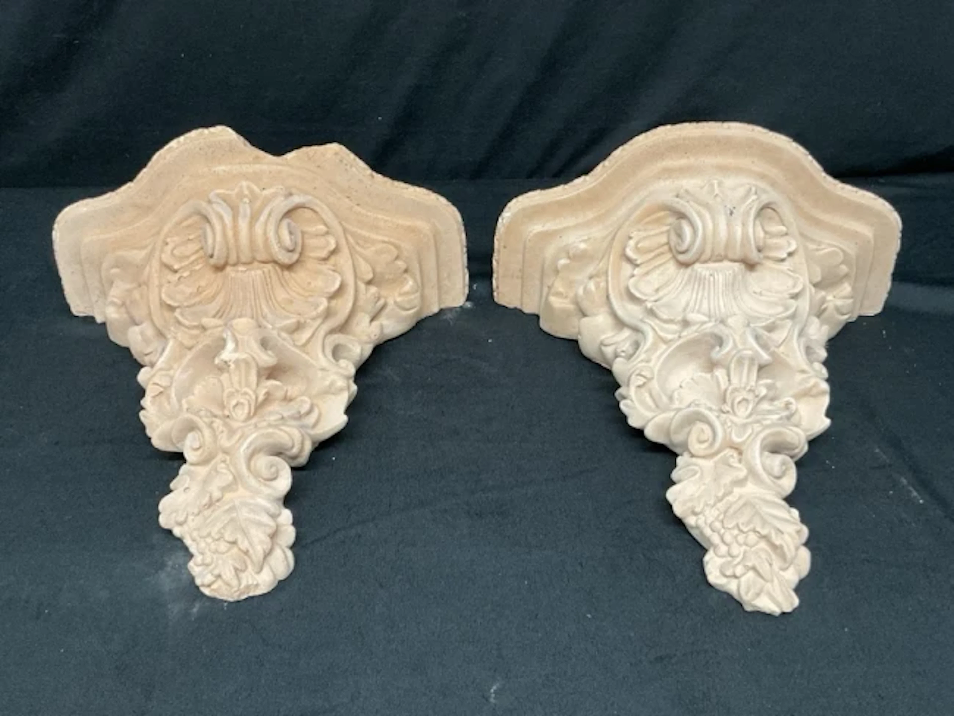 A pair of rococo style plaster wall brackets with serpentine shelves