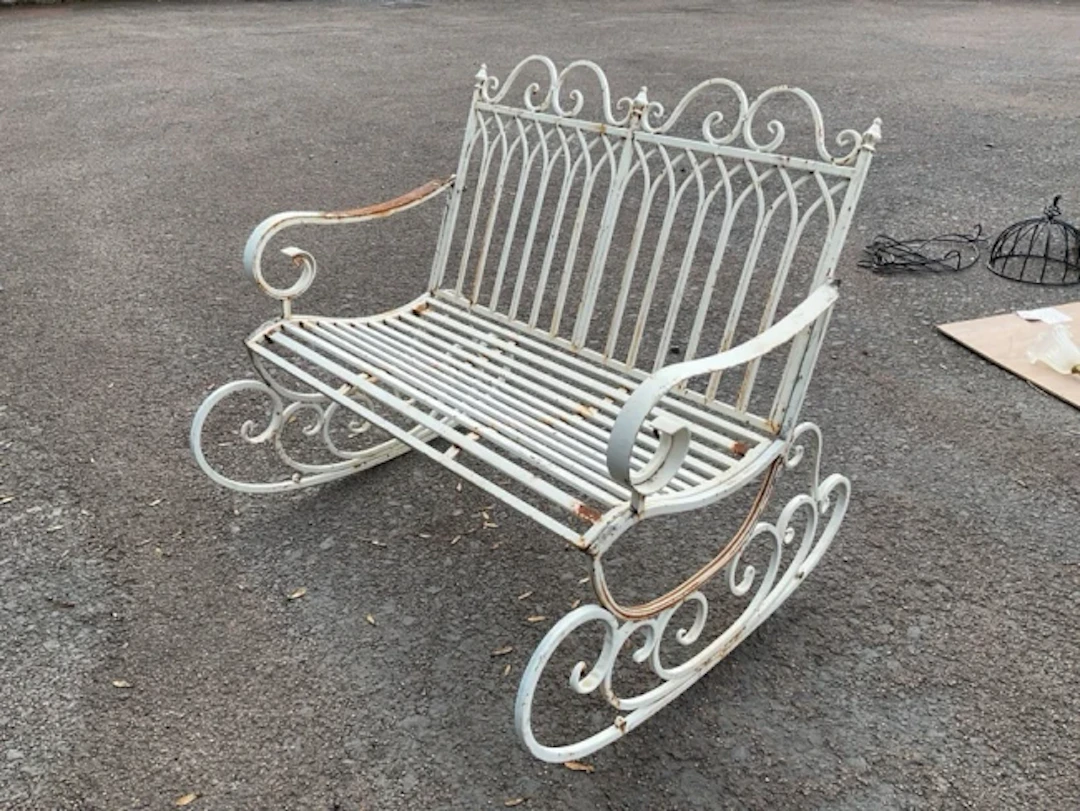 A painted wrought iron garden rocking chair bench with pierced gothic