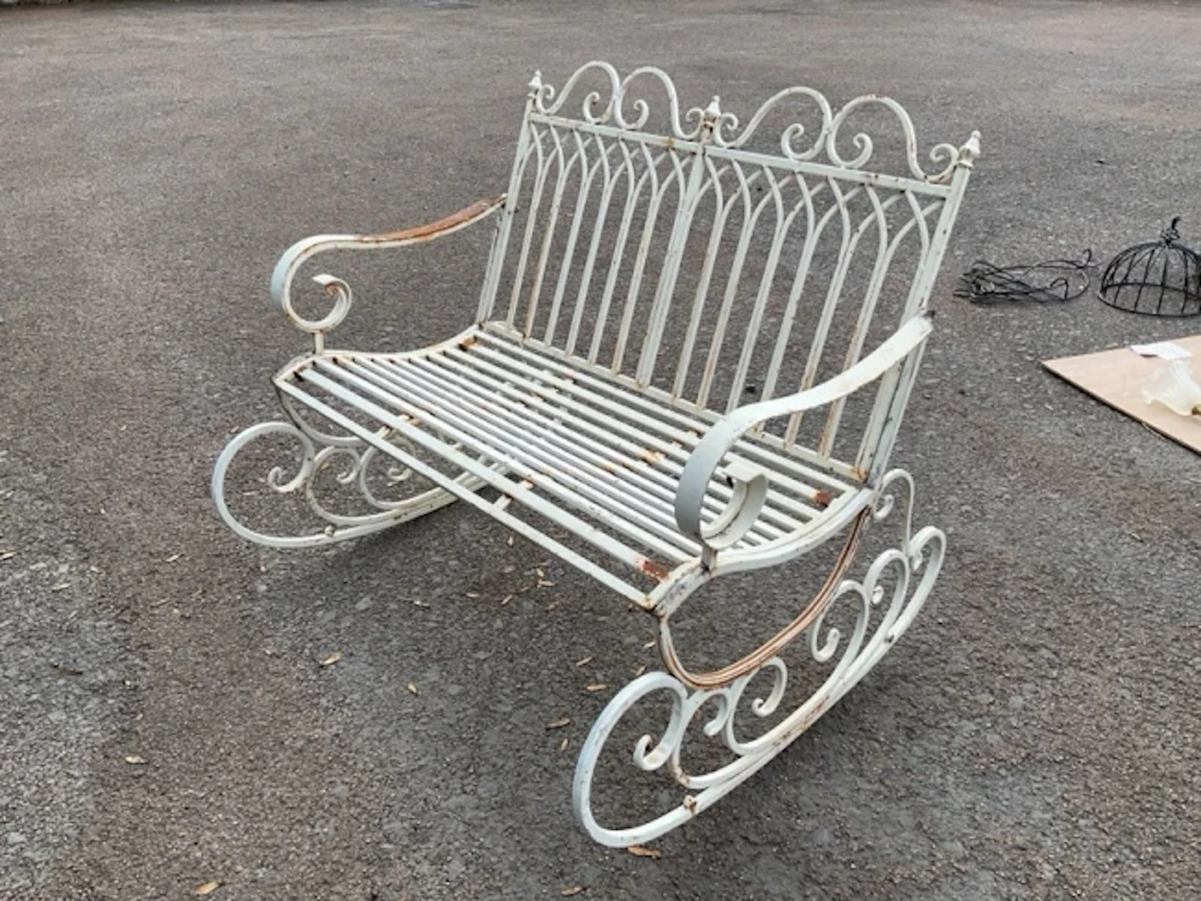 A painted wrought iron garden rocking chair bench with pierced gothic