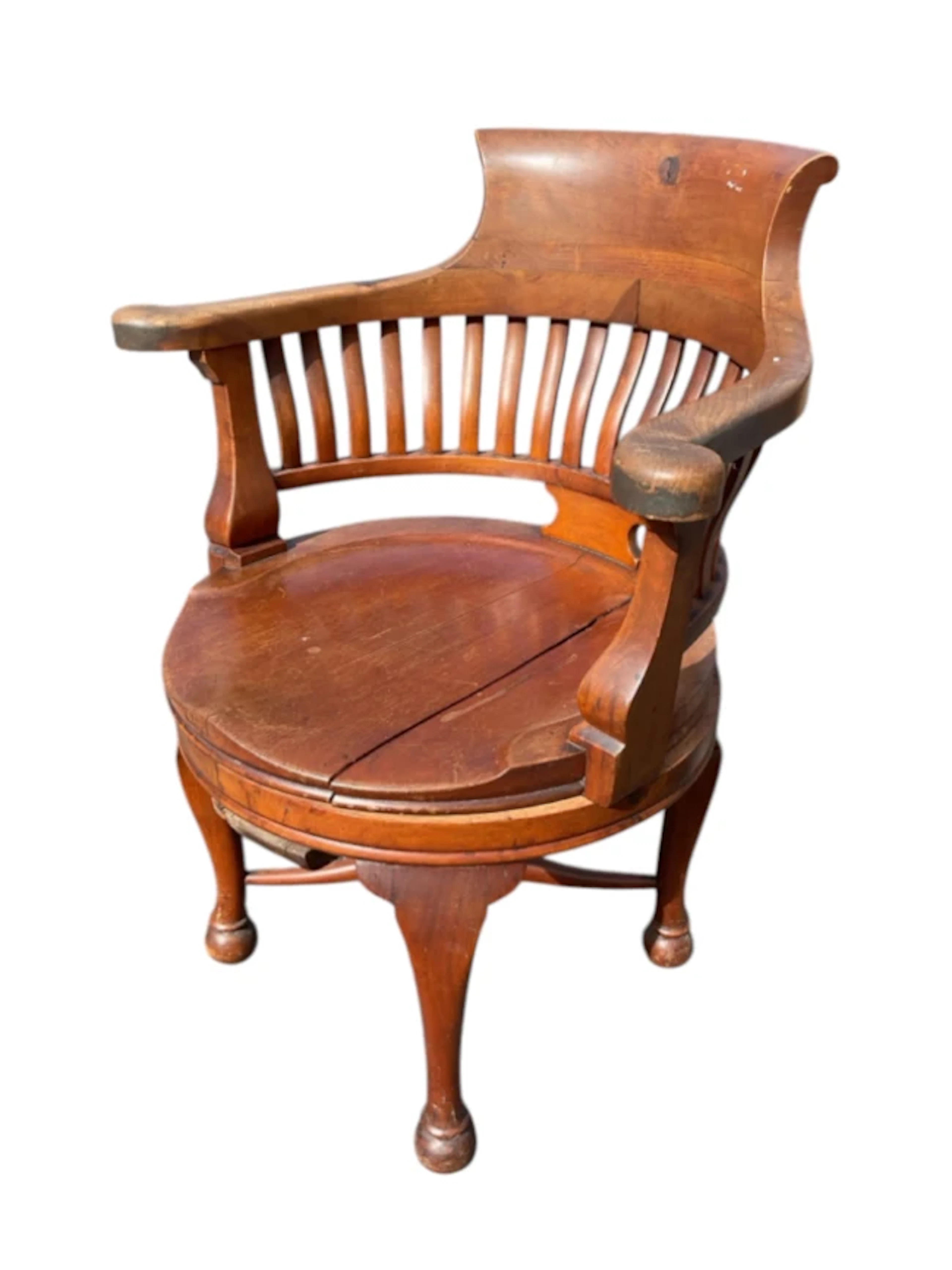 An Edwardian mahogany captains chair with deep backrest and shaped