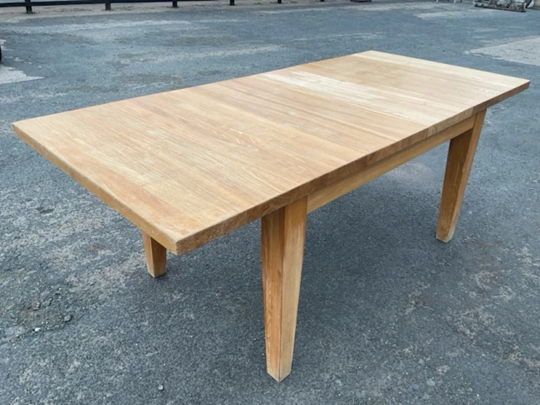 A rectangular extending oak table with two leaves, supported on square