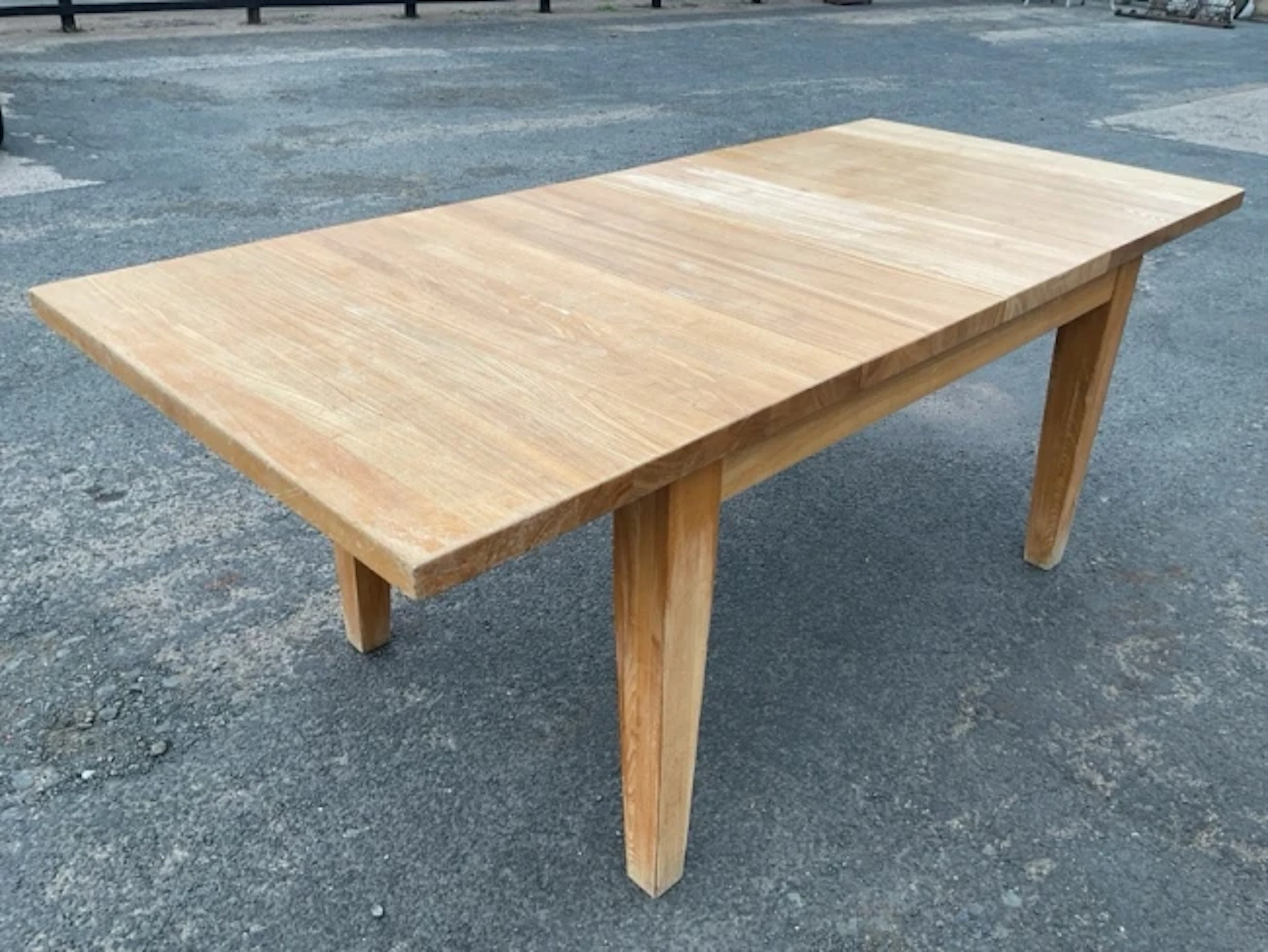 A rectangular extending oak table with two leaves, supported on square