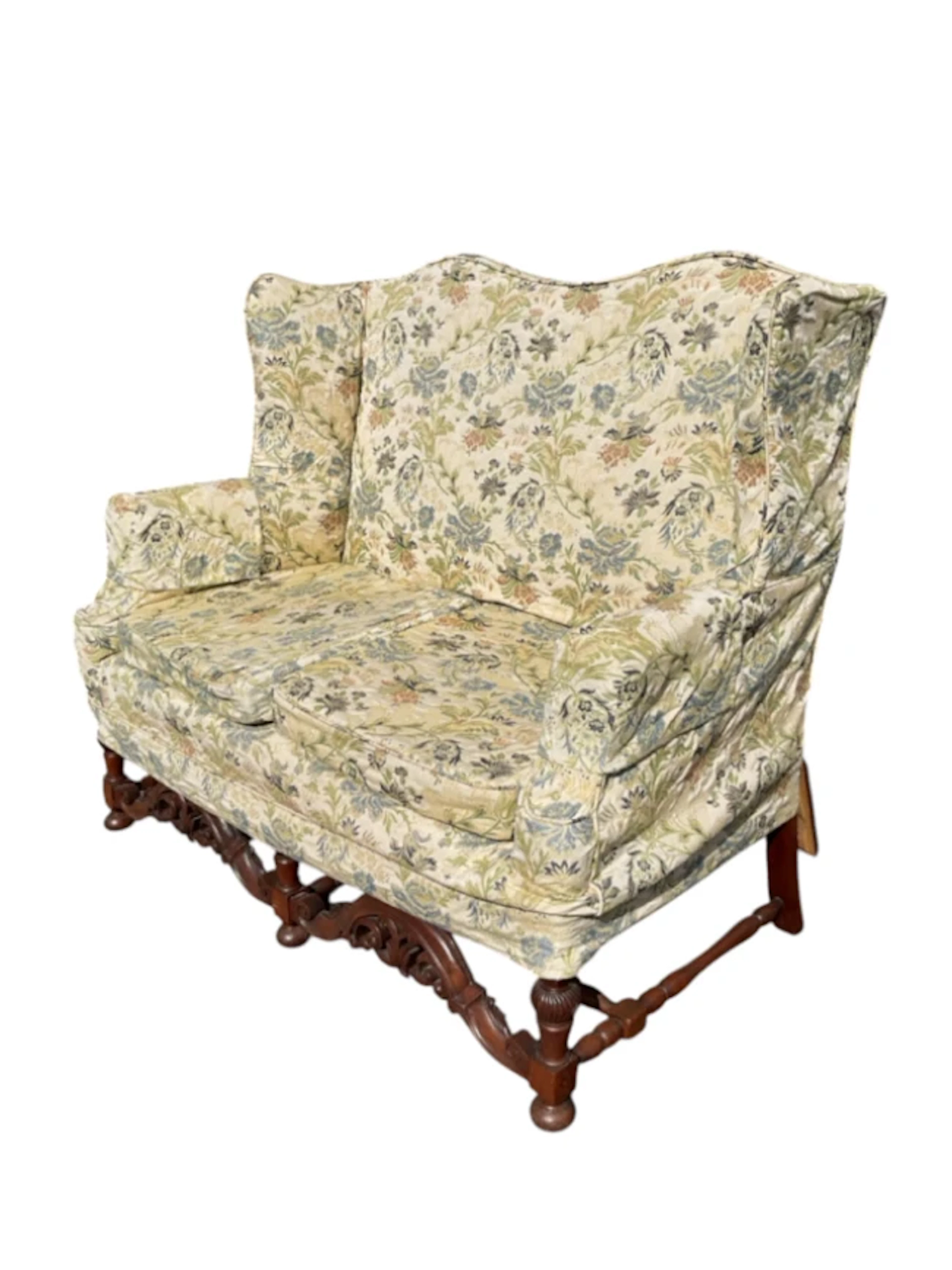 A Queen Anne style sofa with high camel back and shaped wings above