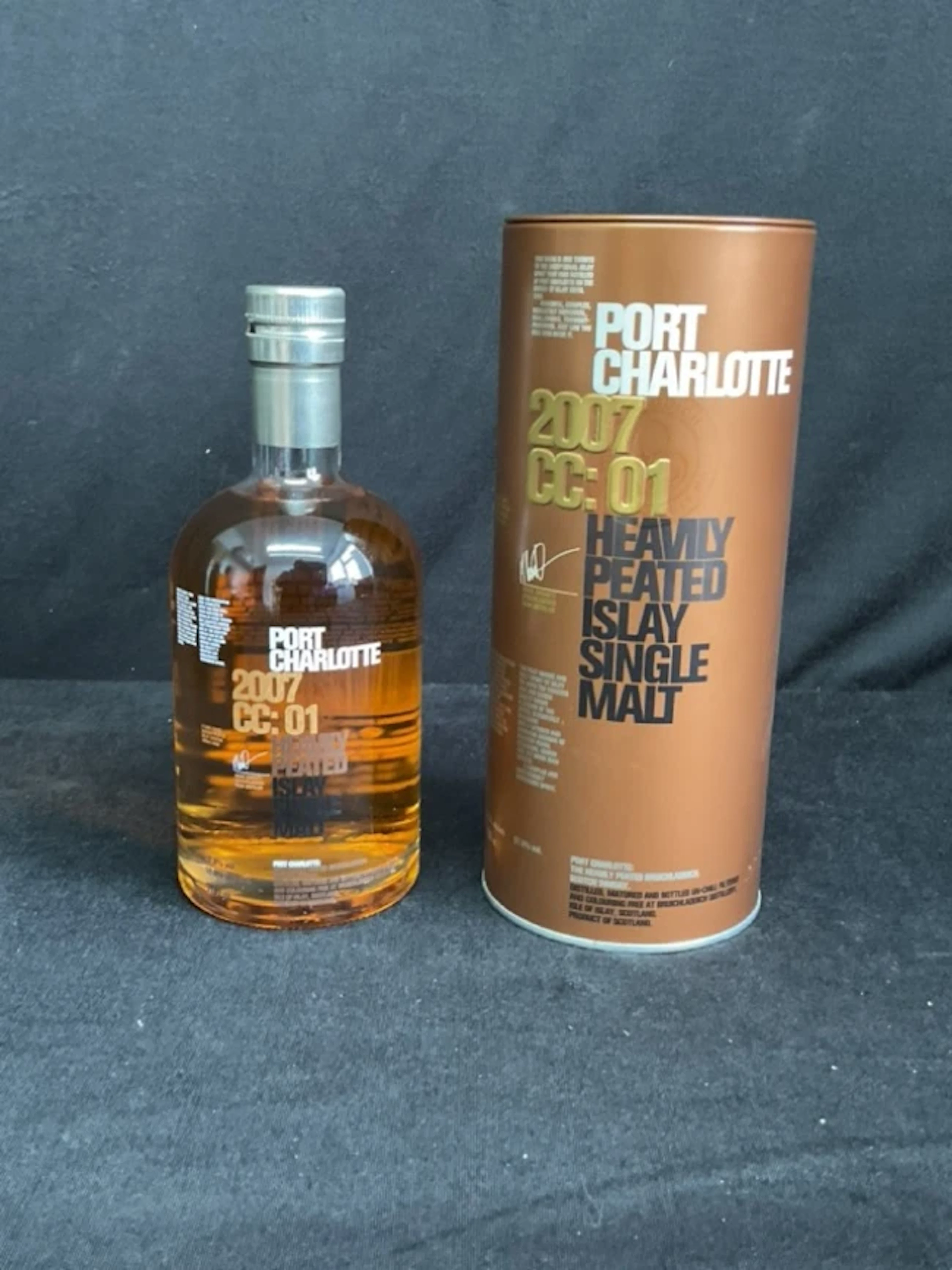A bottle of Port Charlotte heavily peated Islay single malt whisky - tinned.