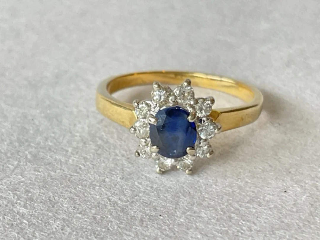 An 18ct gold sapphire cluster ring with central circular stone framed