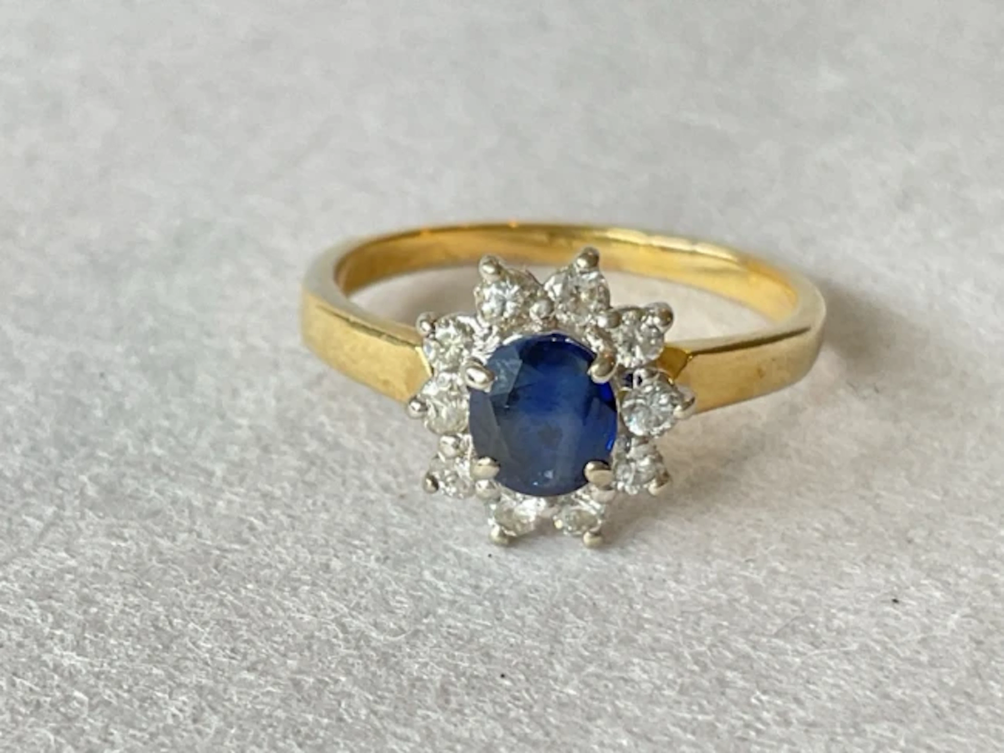 An 18ct gold sapphire cluster ring with central circular stone framed