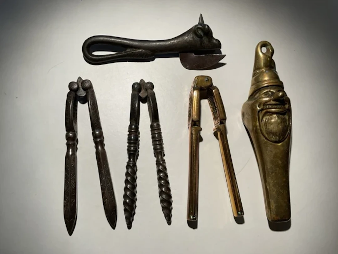 Four old nutcrackers - brass gnome type, twisted handled, scroll engraved