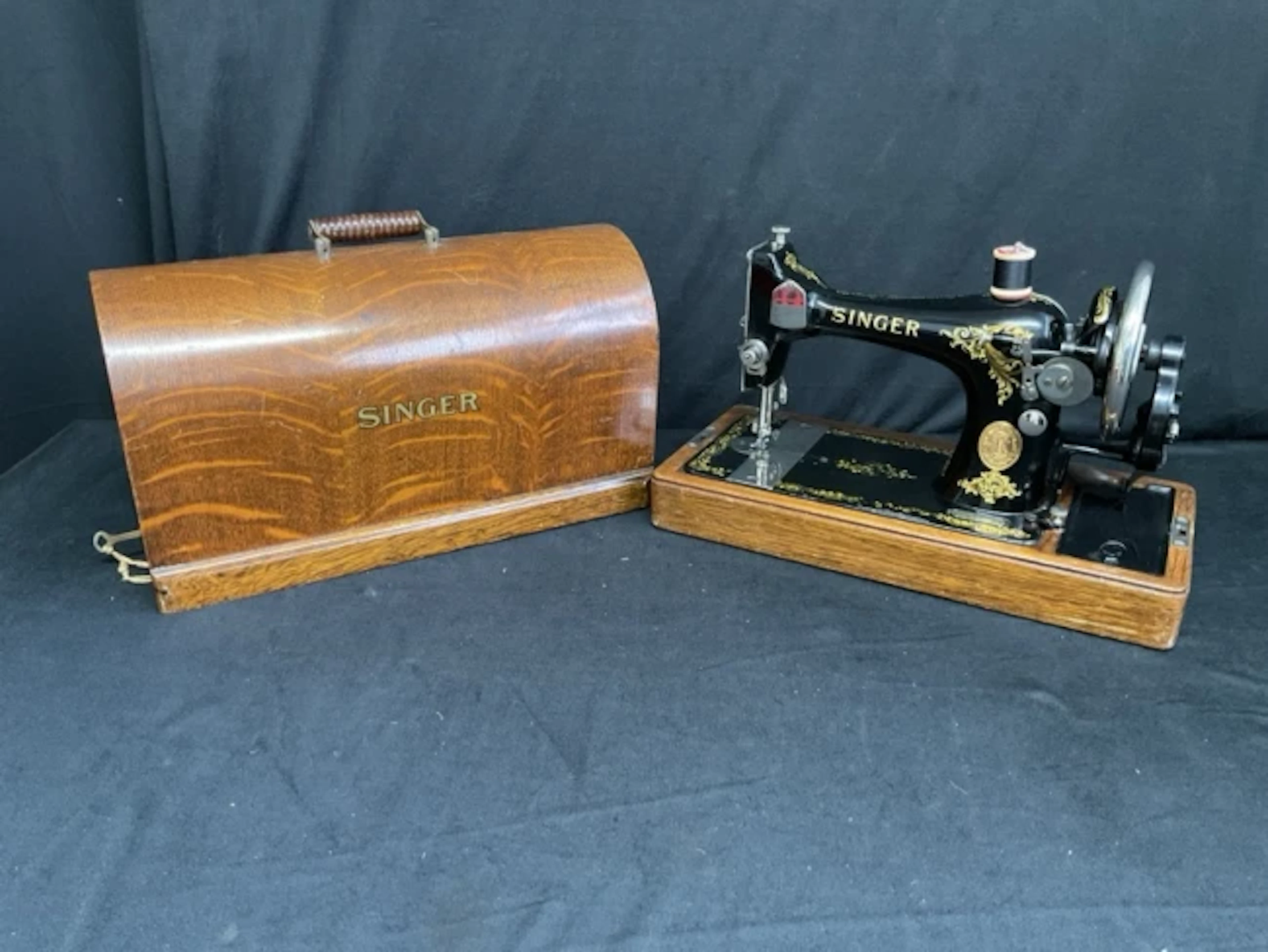 An Edwardian Singer sewing machine in domed oak case with ribbed swing