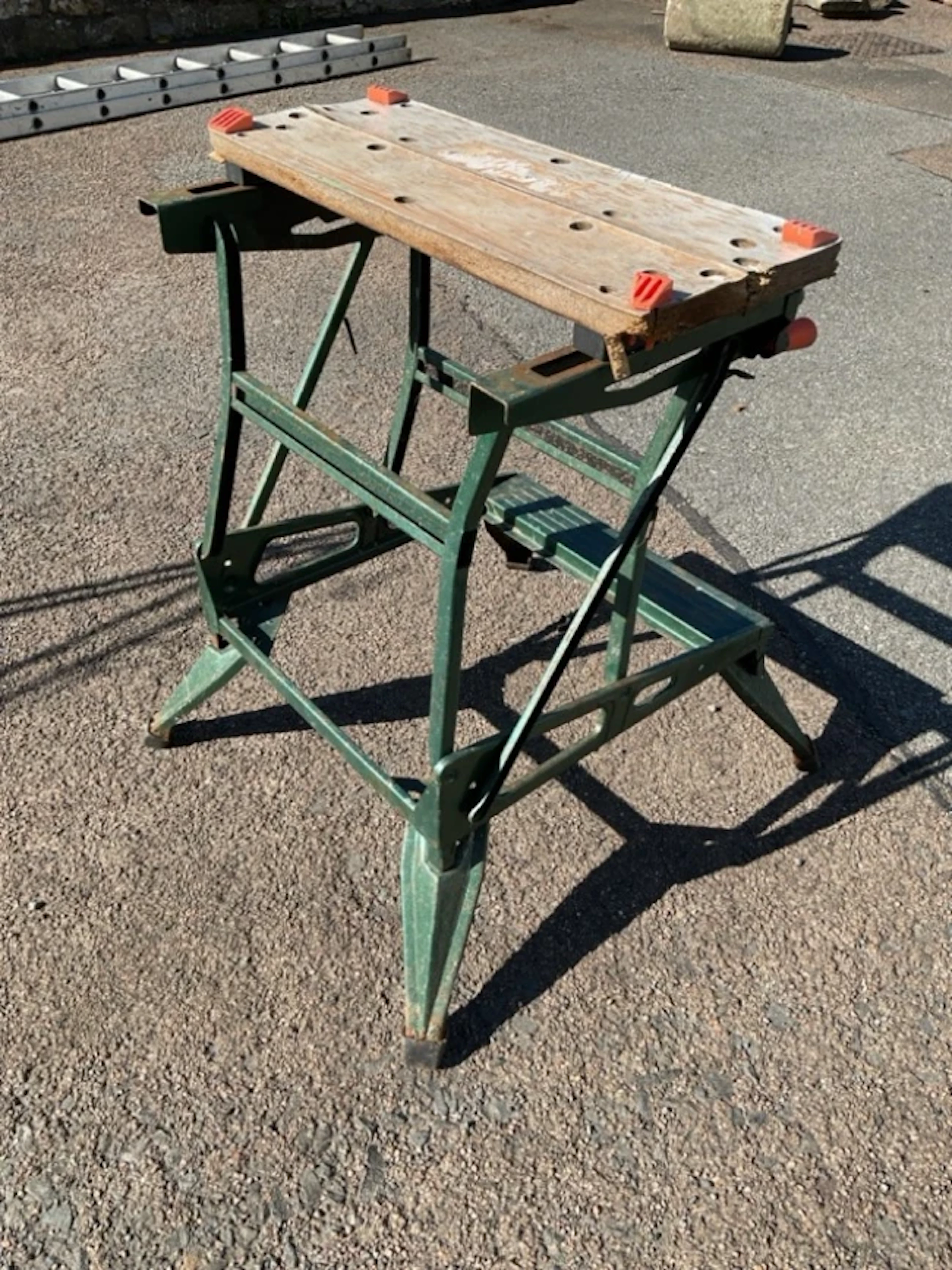 A Black & Decker folding workmate with vice table top above a stand
