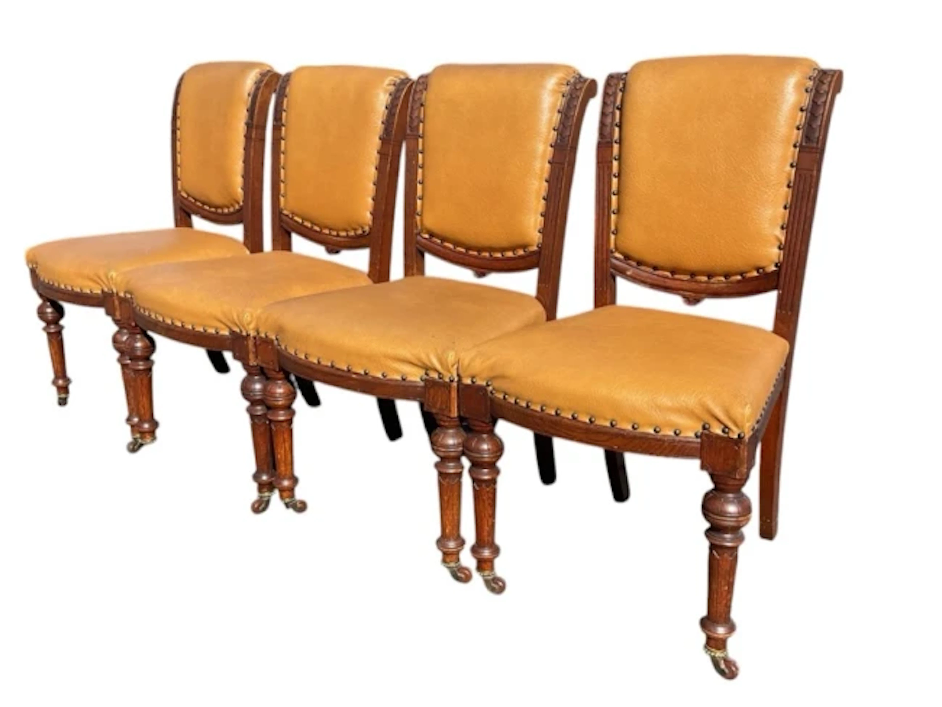 A set of four Victorian oak chairs with studded upholstery, the ribbed
