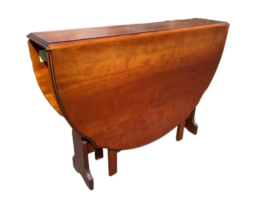A cherry table with scalloped oval moulded top having drop-leaves
