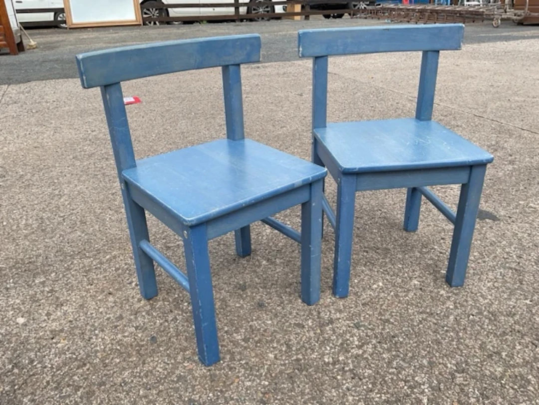 A pair of painted childrens chairs with tablet crestrails above solid