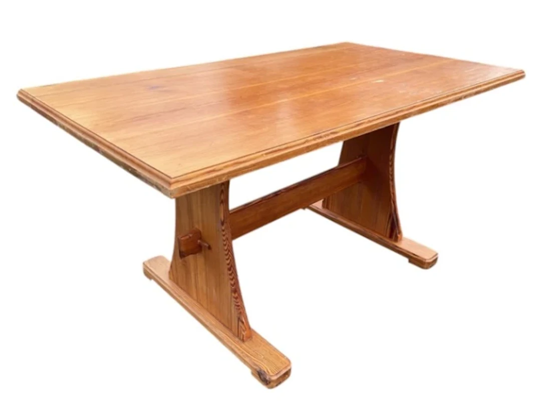 A pine kitchen table with rectangular moulded top on flared trestle