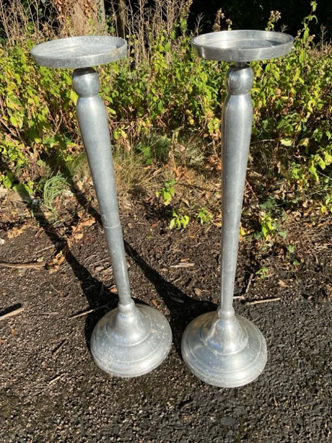 A pair of aluminium jardinière stands with circular platforms on tapering