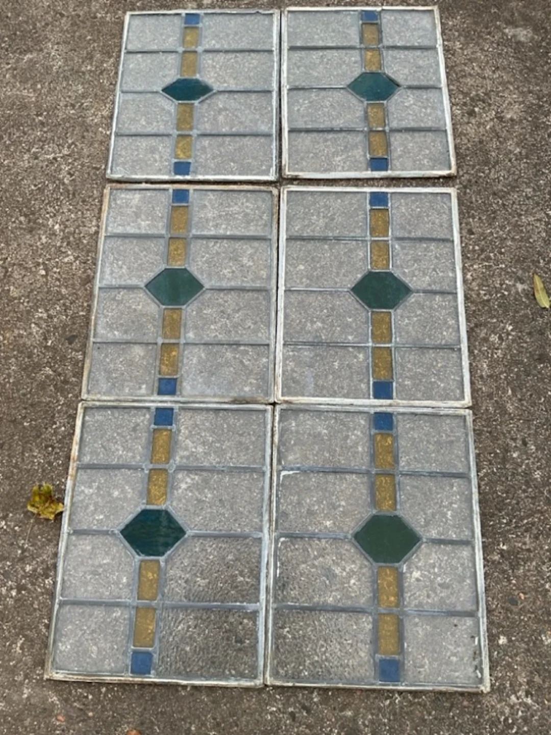 A set of six rectangular leaded glass panels with bands of coloured