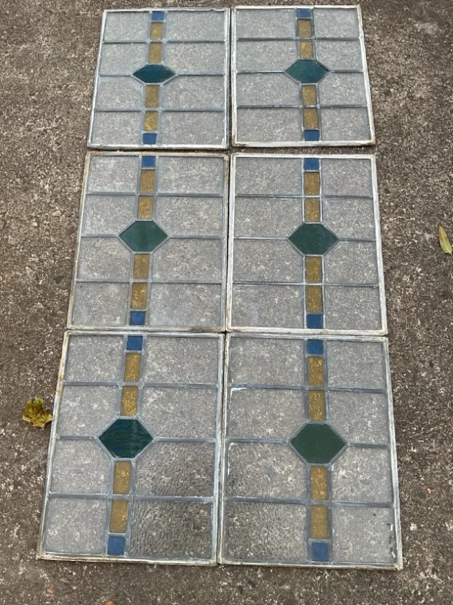 A set of six rectangular leaded glass panels with bands of coloured
